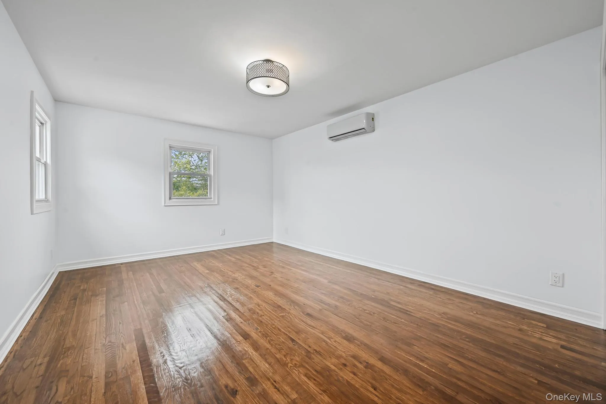 Empty room featuring dark wood-style flooring and baseboards Empty room featuring dark wood-style flooring and baseboards
