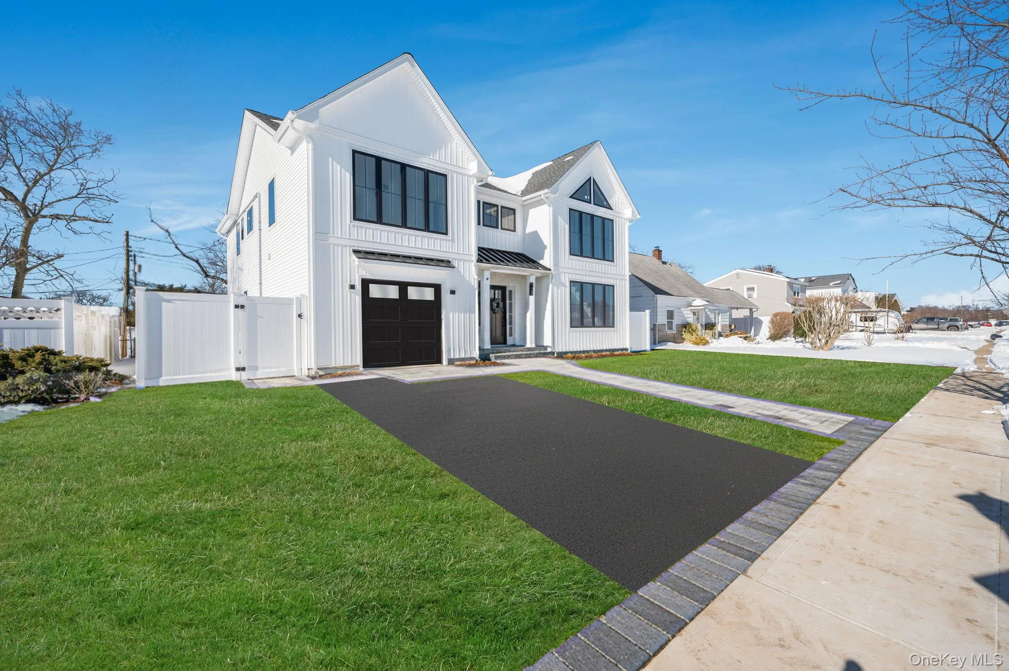 Modern Colonial exterior with board and batten style siding, black framed windows, and a covered entry that creates a strong, custom curb appeal. Modern Colonial exterior with board and batten style siding, black framed windows, and a covered entry that creates a strong, custom curb appeal.