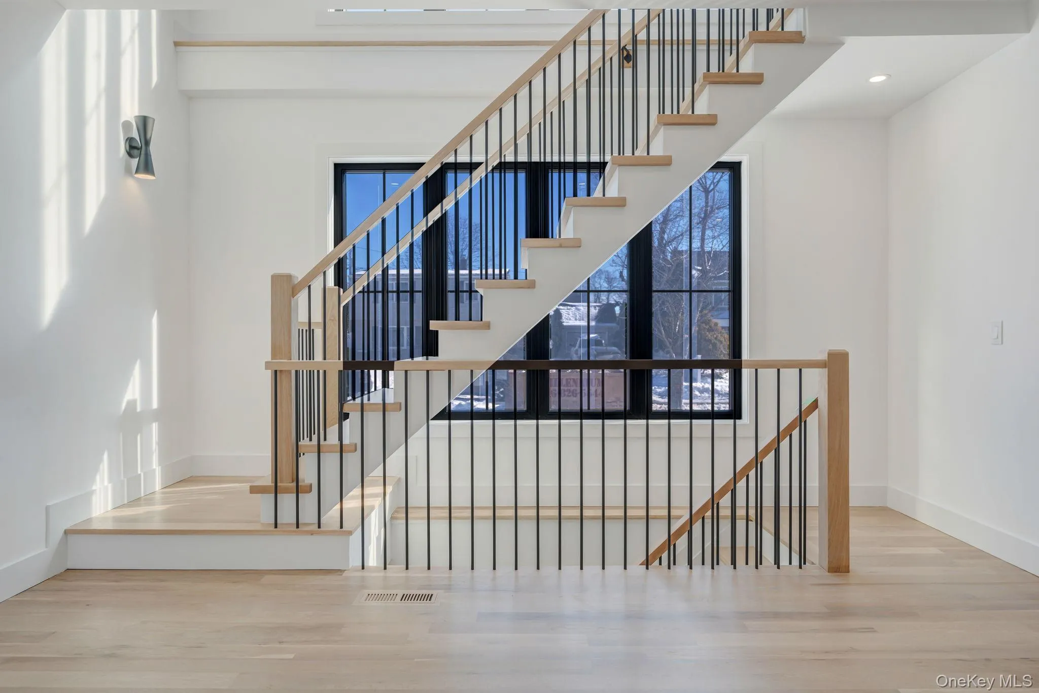Striking staircase with modern railing and large window wall that brings light into both levels and adds architectural character. Striking staircase with modern railing and large window wall that brings light into both levels and adds architectural character.