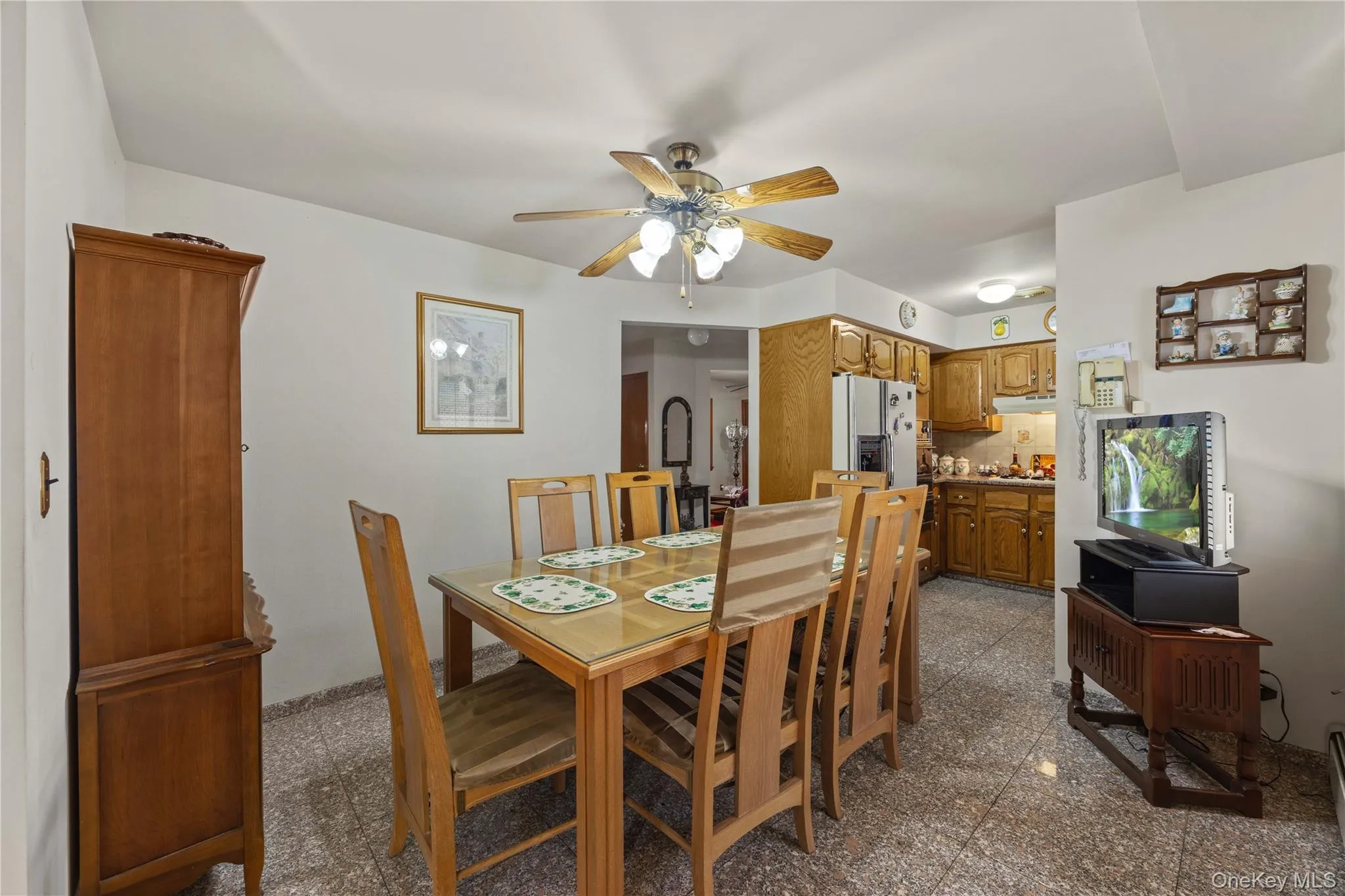 Dining area featuring a ceiling fan with integrated lighting, a tiled floor, and a clear line of sight to the kitchen Dining area featuring a ceiling fan with integrated lighting, a tiled floor, and a clear line of sight to the kitchen