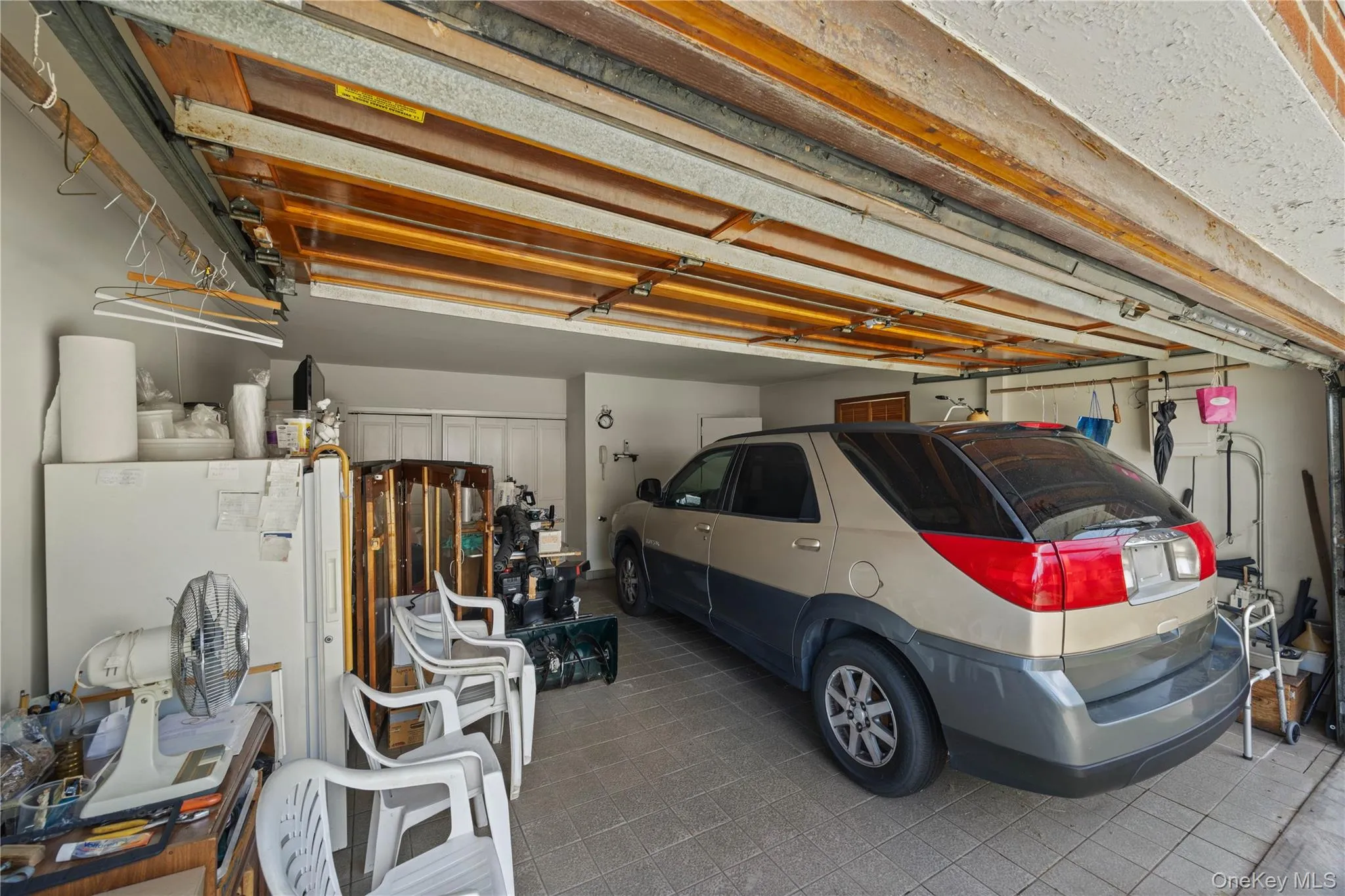 Enclosed garage featuring concrete flooring and a paneled overhead door Enclosed garage featuring concrete flooring and a paneled overhead door