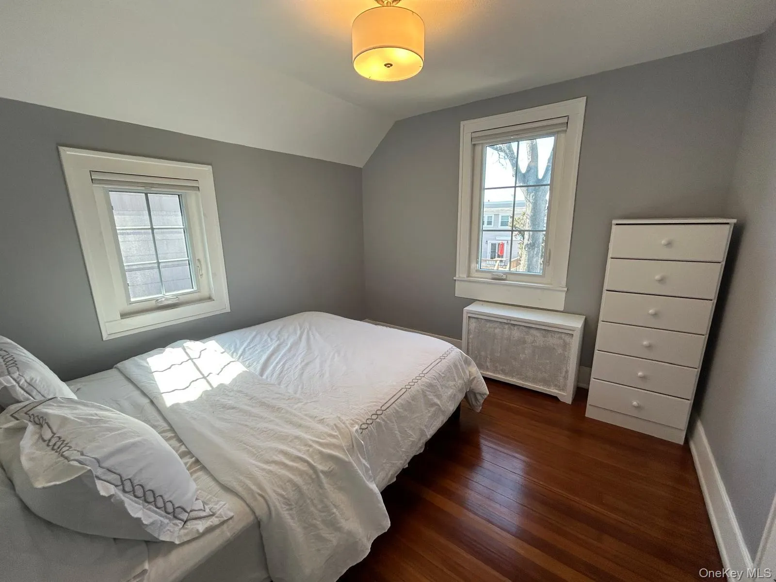 Bedroom with lofted ceiling, dark wood finished floors, and baseboards Bedroom with lofted ceiling, dark wood finished floors, and baseboards