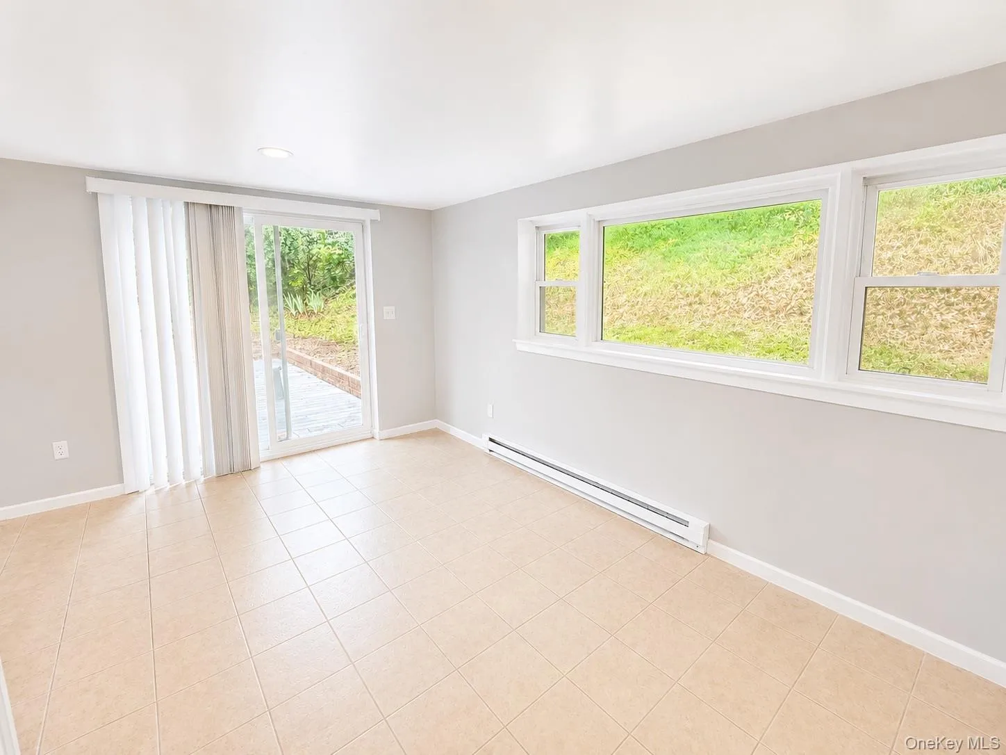 Tiled flooring, white trim, sliding glass door, recessed lighting, and multiple windows Tiled flooring, white trim, sliding glass door, recessed lighting, and multiple windows