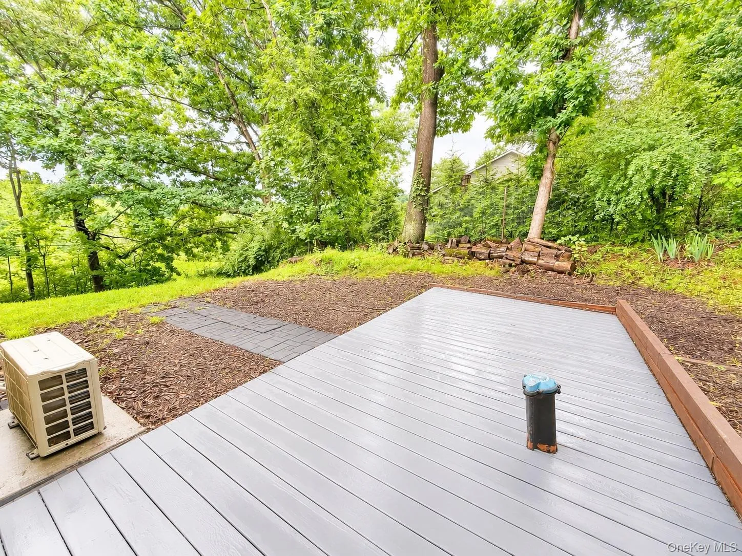Expansive composite deck featuring clean-lined composite decking with a black metal post detail, anchored by mature shade trees and lush landscaping Expansive composite deck featuring clean-lined composite decking with a black metal post detail, anchored by mature shade trees and lush landscaping
