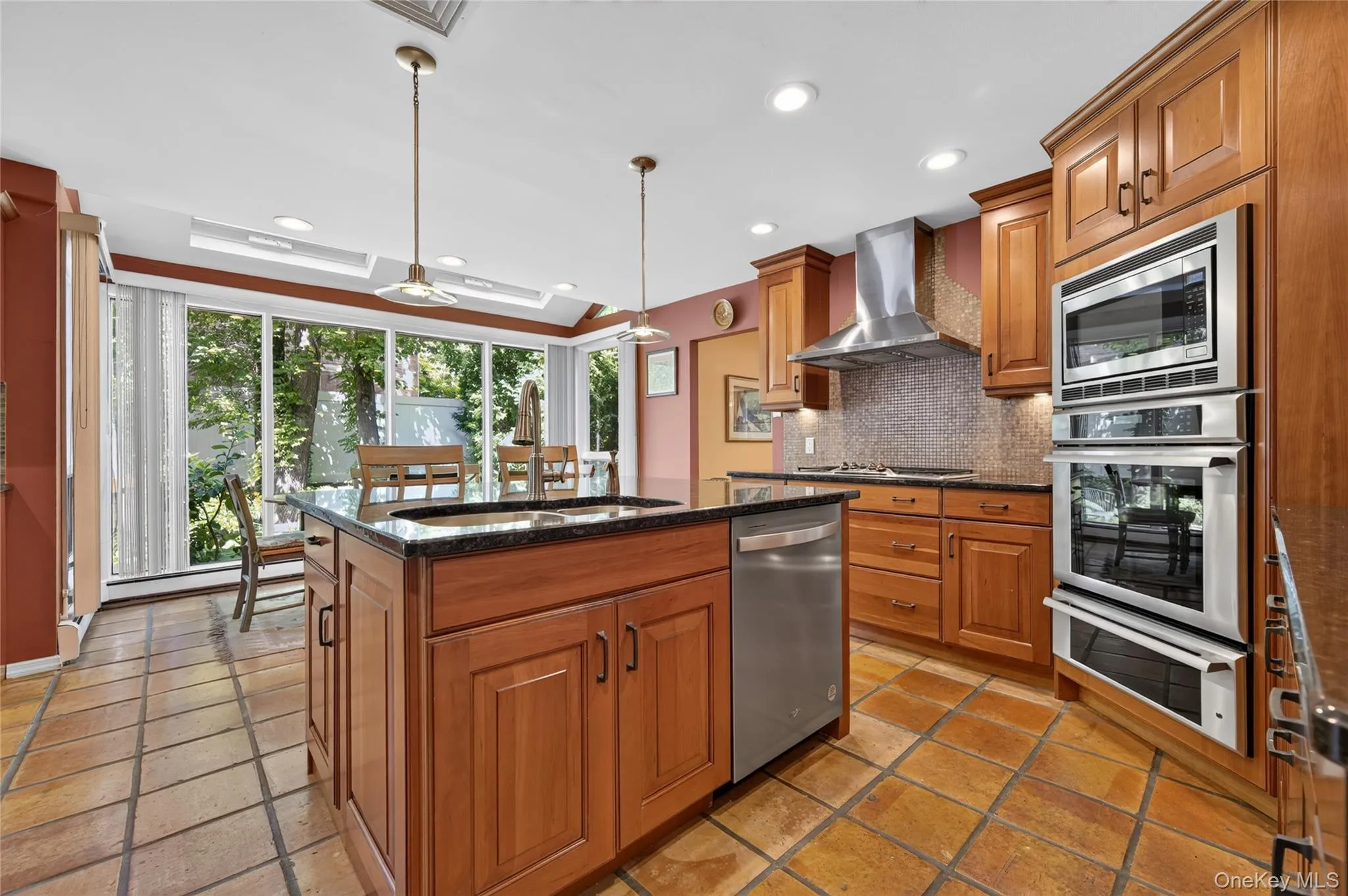 Gourmet kitchen with stainless steel appliances, center island, dual wall ovens, warming drawer and a range hood Gourmet kitchen with stainless steel appliances, center island, dual wall ovens, warming drawer and a range hood
