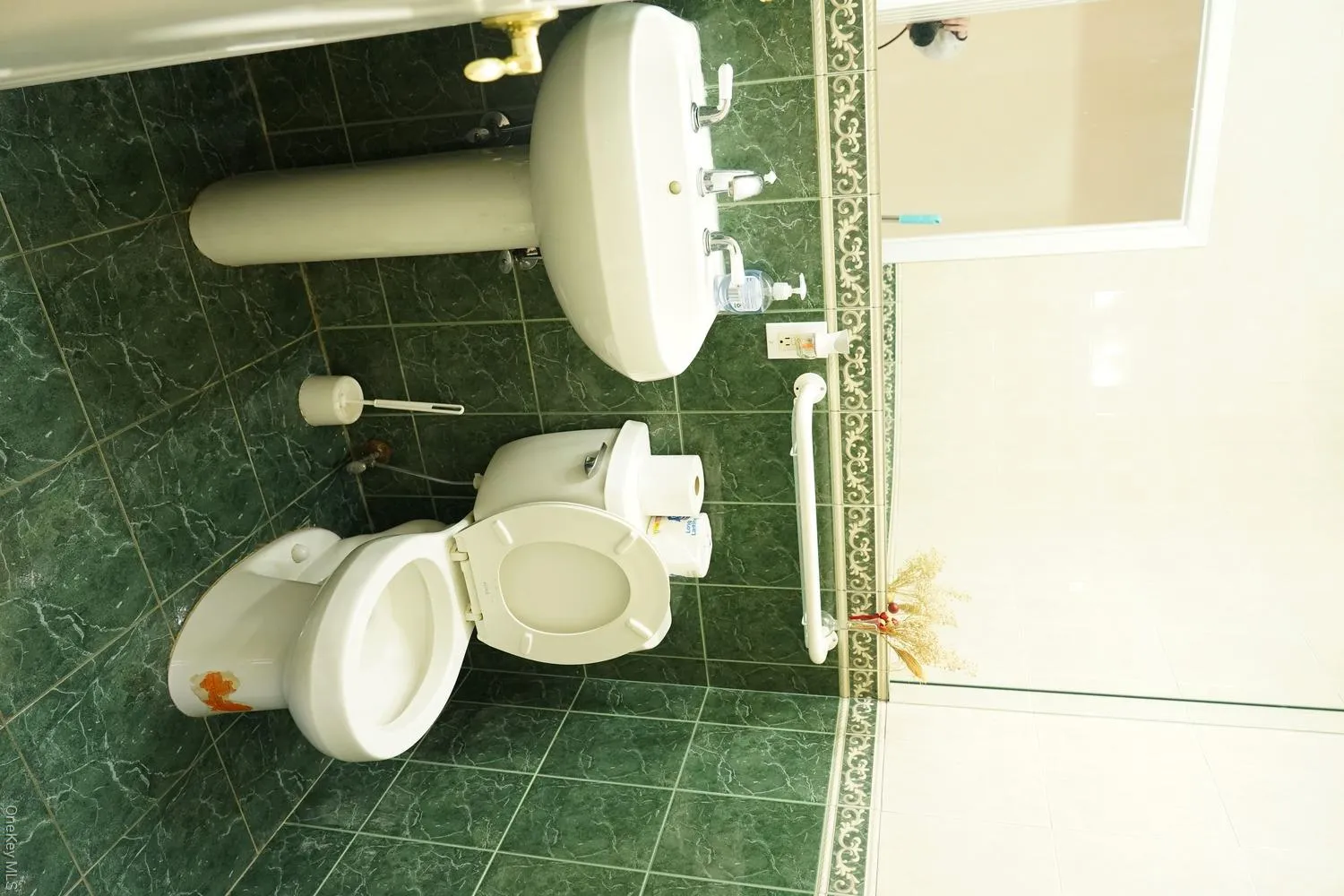 Bathroom featuring toilet, wainscoting, and tile walls Bathroom featuring toilet, wainscoting, and tile walls