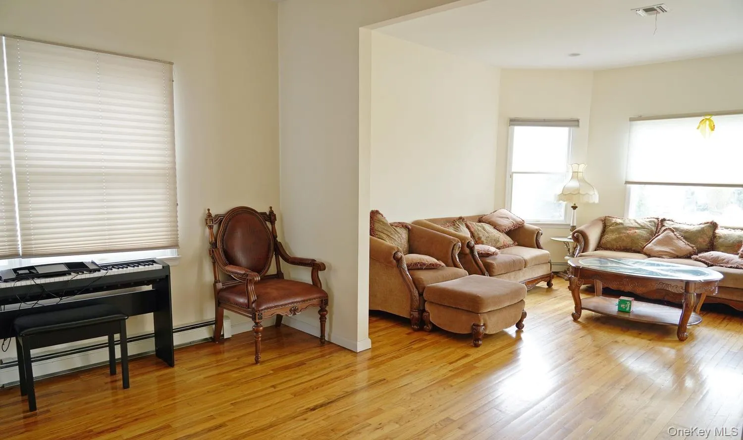 Living room featuring light wood-type flooring and visible vents Living room featuring light wood-type flooring and visible vents