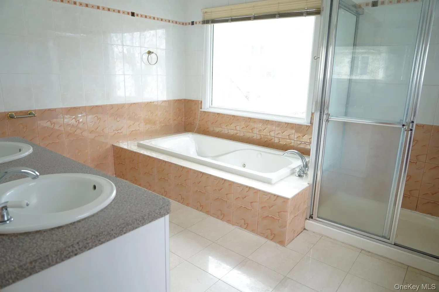 Full bath featuring a sink, double vanity, a stall shower, tile walls, and a garden tub Full bath featuring a sink, double vanity, a stall shower, tile walls, and a garden tub