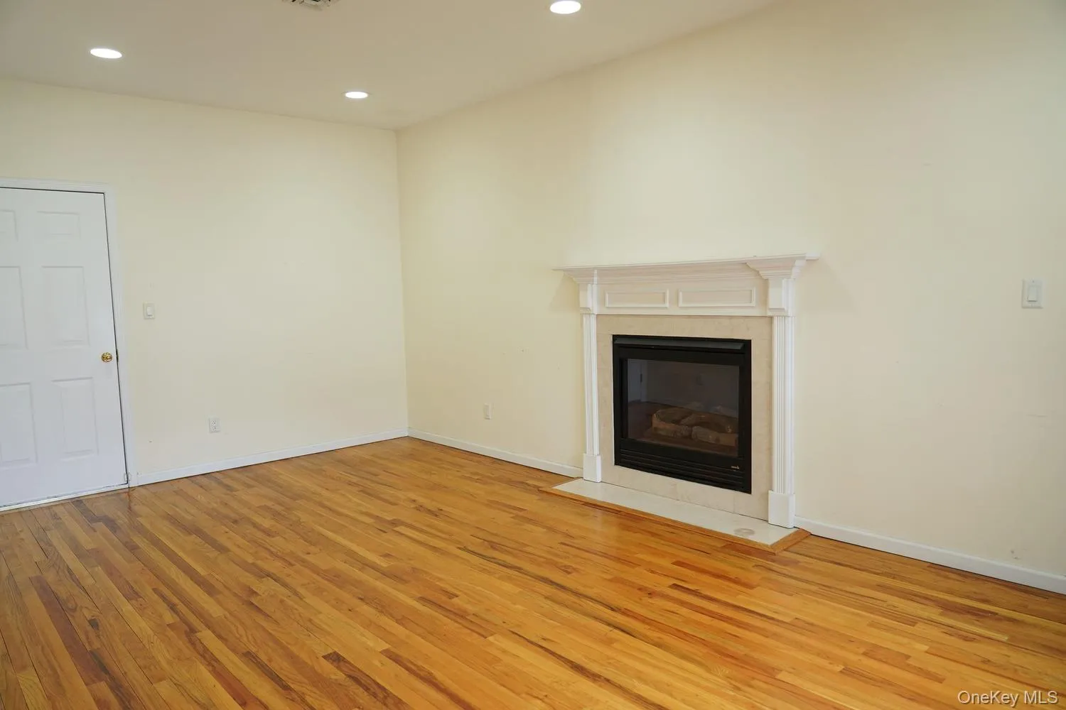 Unfurnished living room with light wood-style flooring, recessed lighting, a tile fireplace, and baseboards Unfurnished living room with light wood-style flooring, recessed lighting, a tile fireplace, and baseboards