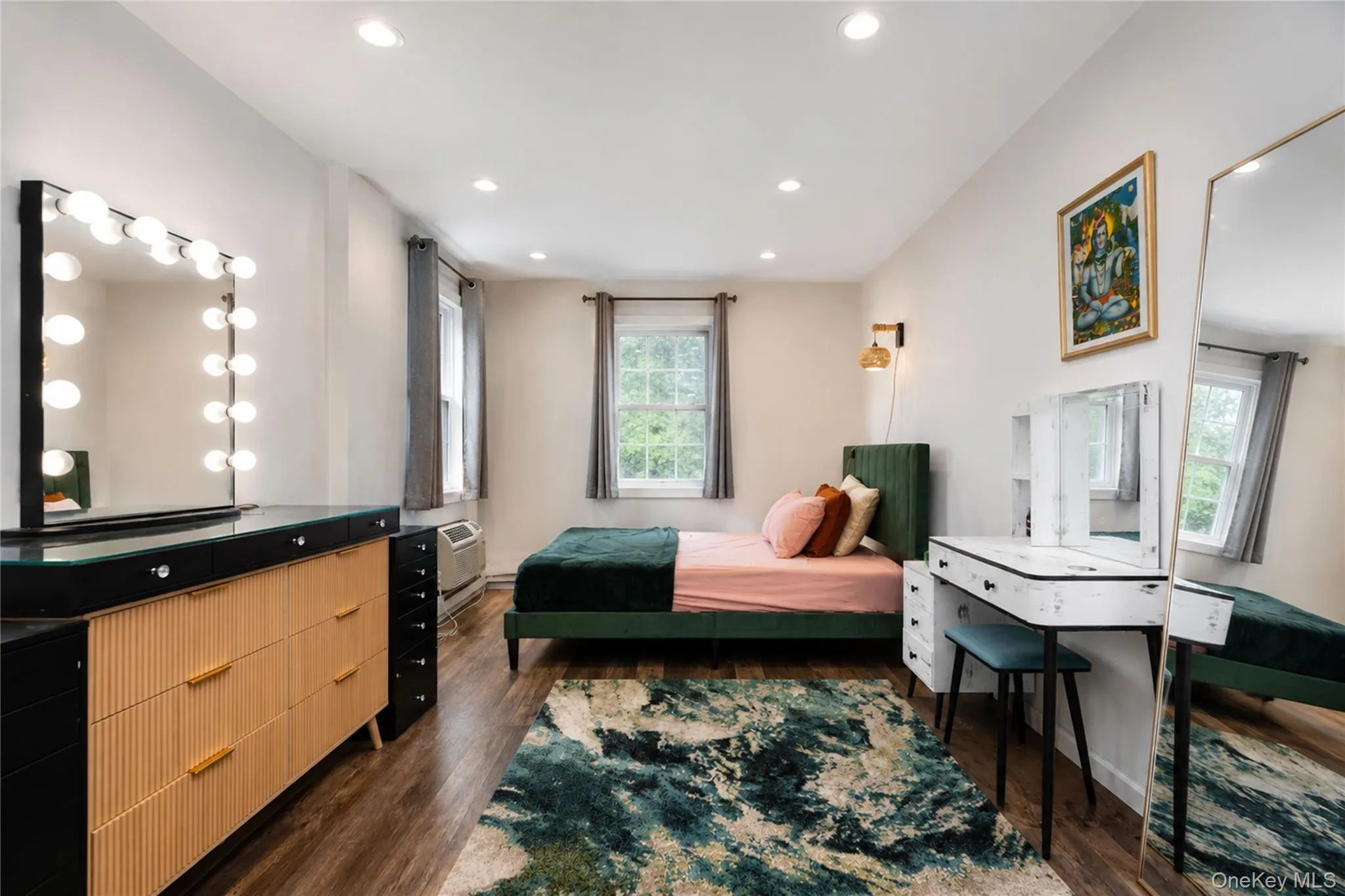Room featuring wood-finish flooring, recessed lighting, and two windows with natural light Room featuring wood-finish flooring, recessed lighting, and two windows with natural light