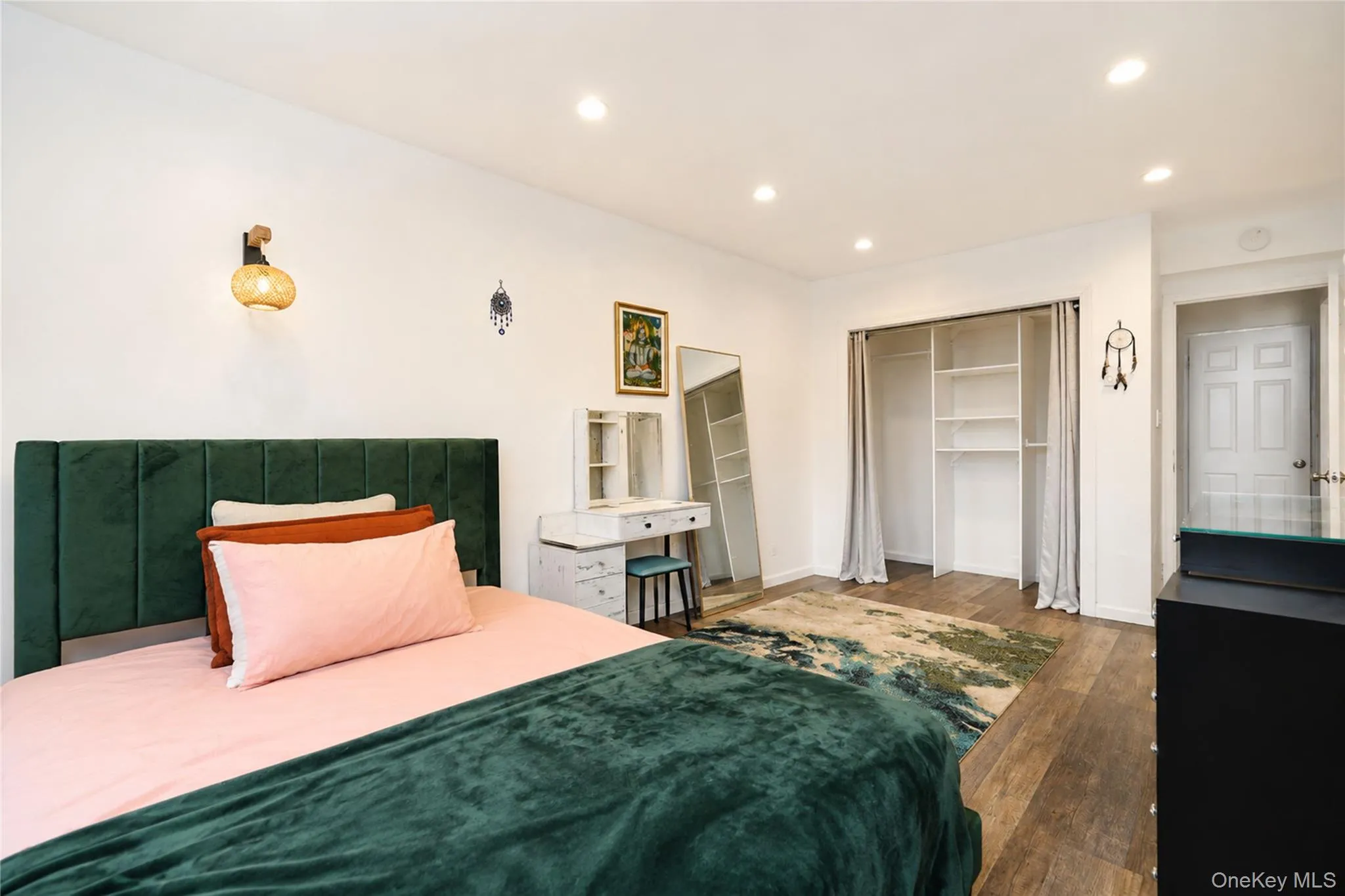 Bedroom featuring wood-finish flooring, recessed lighting, and a built-in closet with shelving Bedroom featuring wood-finish flooring, recessed lighting, and a built-in closet with shelving
