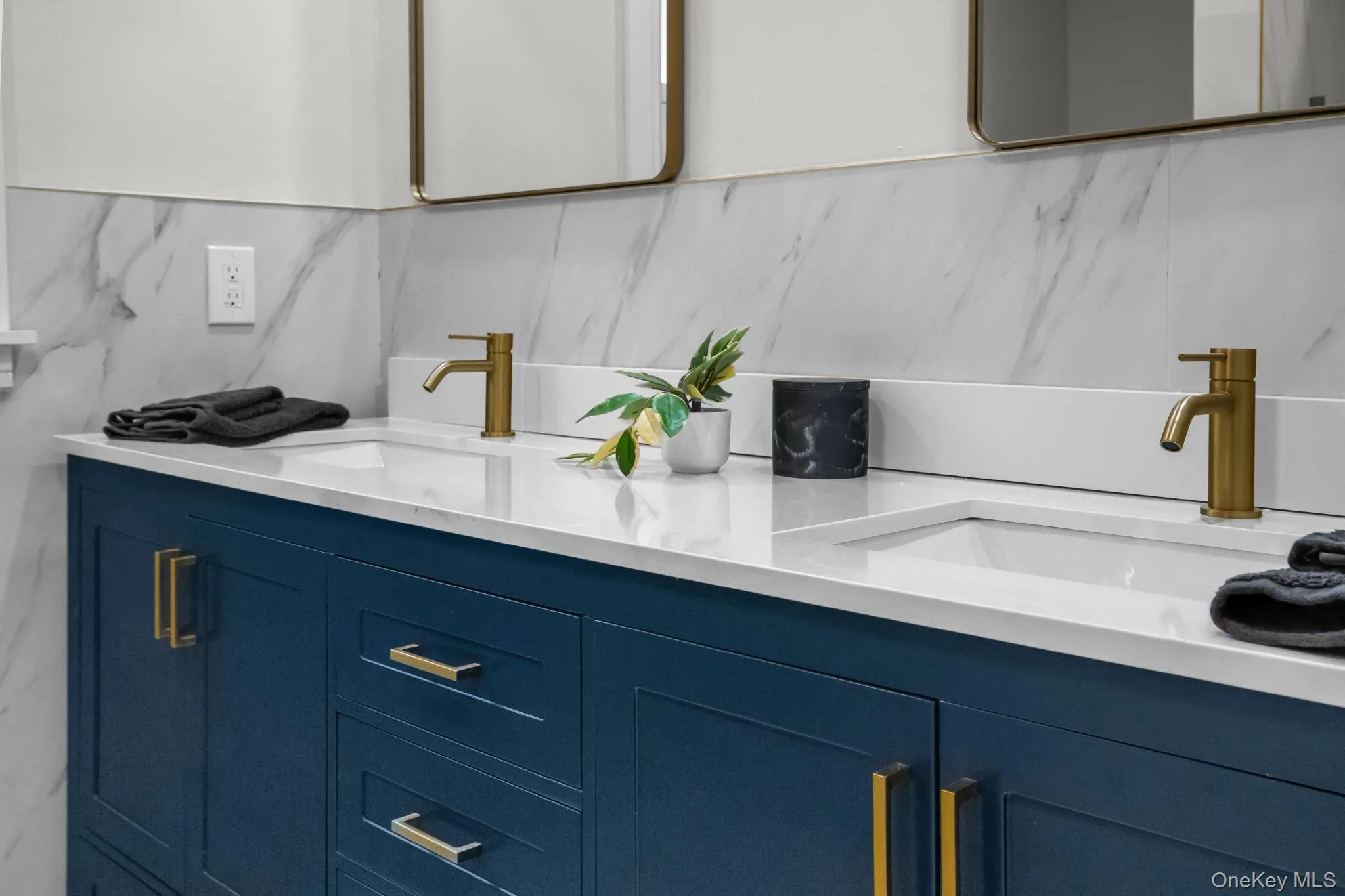 Rich navy cabinetry paired with quartz counters and gold hardware creates a sophisticated yet serene space perfect for daily routines or a spa-like unwind. Rich navy cabinetry paired with quartz counters and gold hardware creates a sophisticated yet serene space perfect for daily routines or a spa-like unwind.