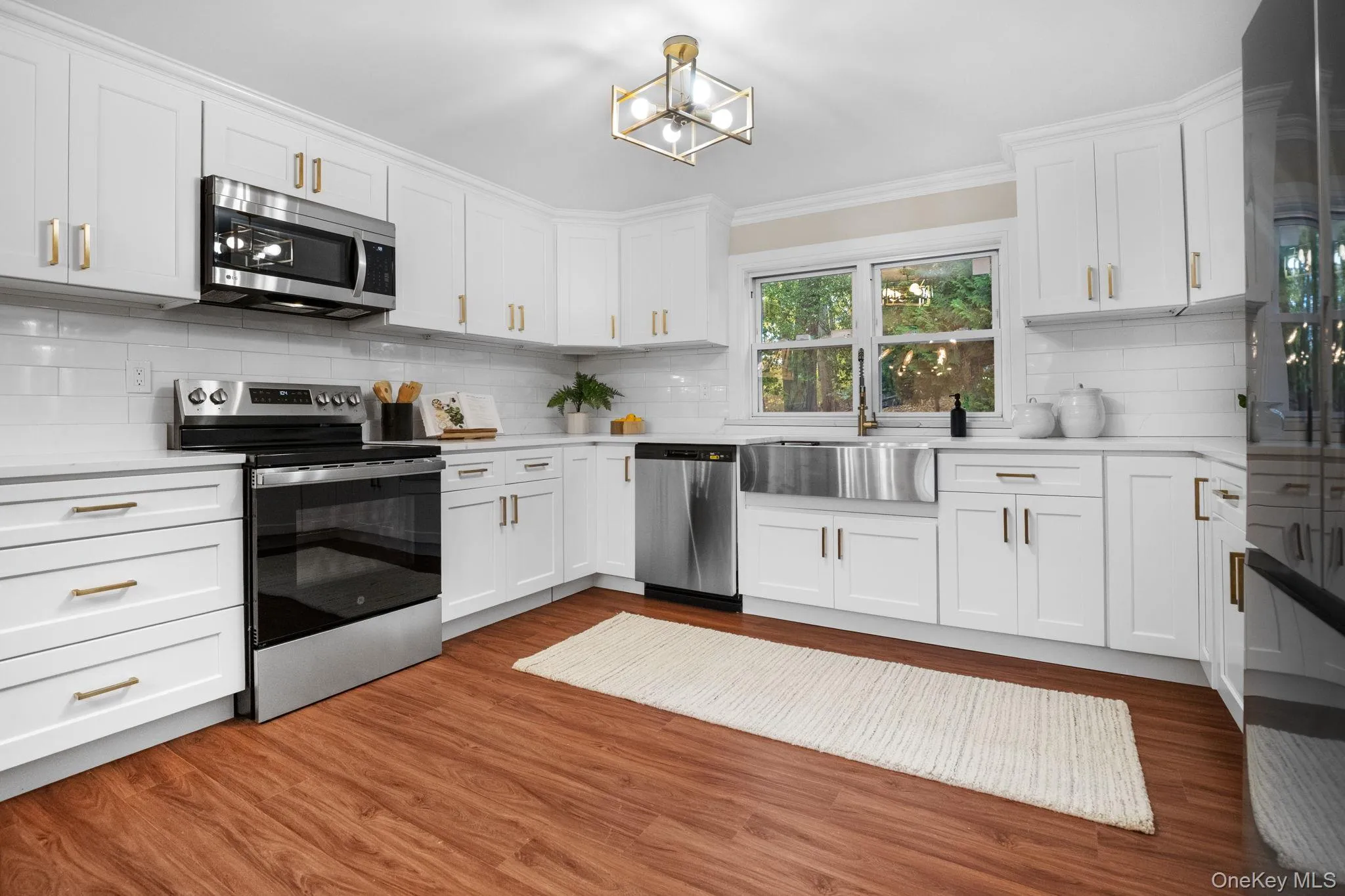 Sleek quartz counters and stainless steel appliances highlight the fresh, modern design of this fully renovated kitchen. Sleek quartz counters and stainless steel appliances highlight the fresh, modern design of this fully renovated kitchen.