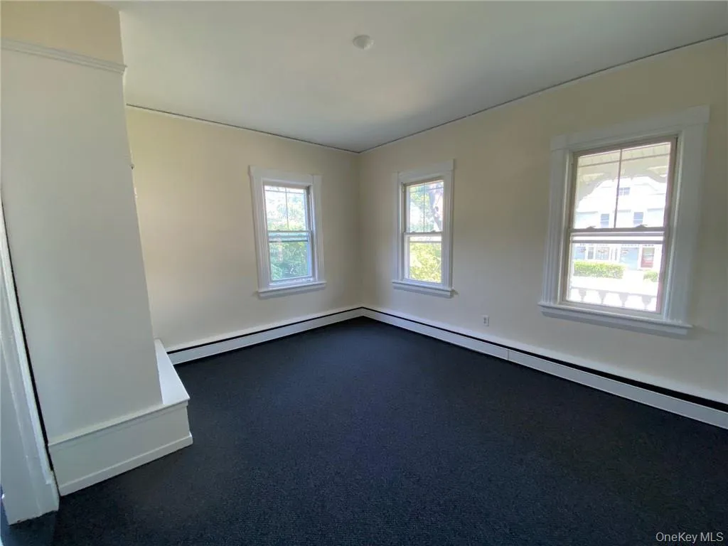 Bedroom with new carpet and baseboard heating unit Bedroom with new carpet and baseboard heating unit
