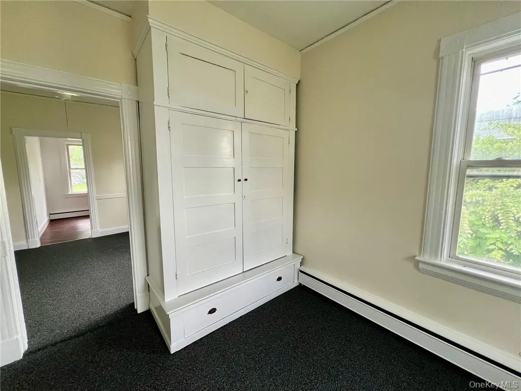 Bedroom with built in closet with baseboard heating Bedroom with built in closet with baseboard heating