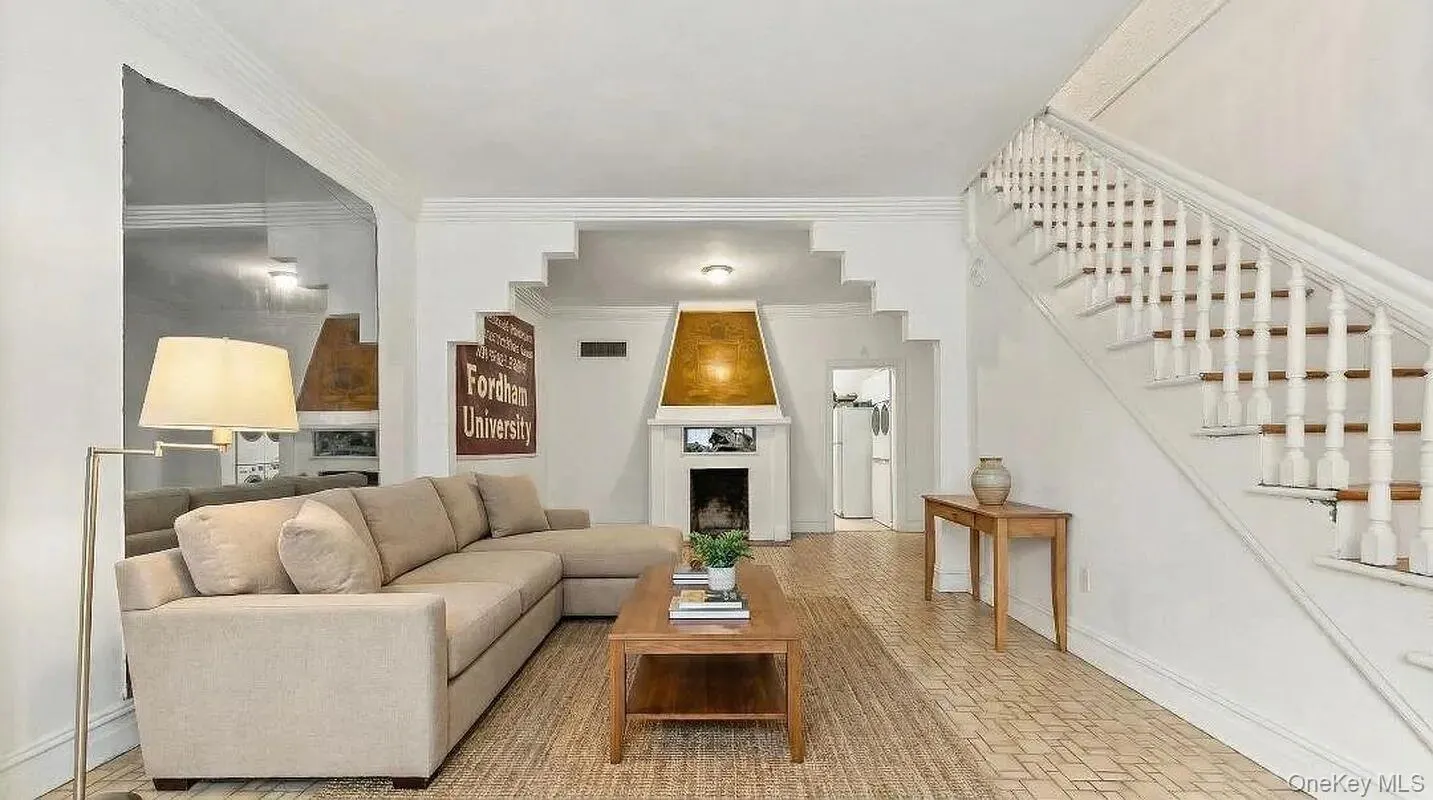 Spacious living room, featuring high ceilings, crown moldings, abundant natural light, and a decorative fireplace. Spacious living room, featuring high ceilings, crown moldings, abundant natural light, and a decorative fireplace.