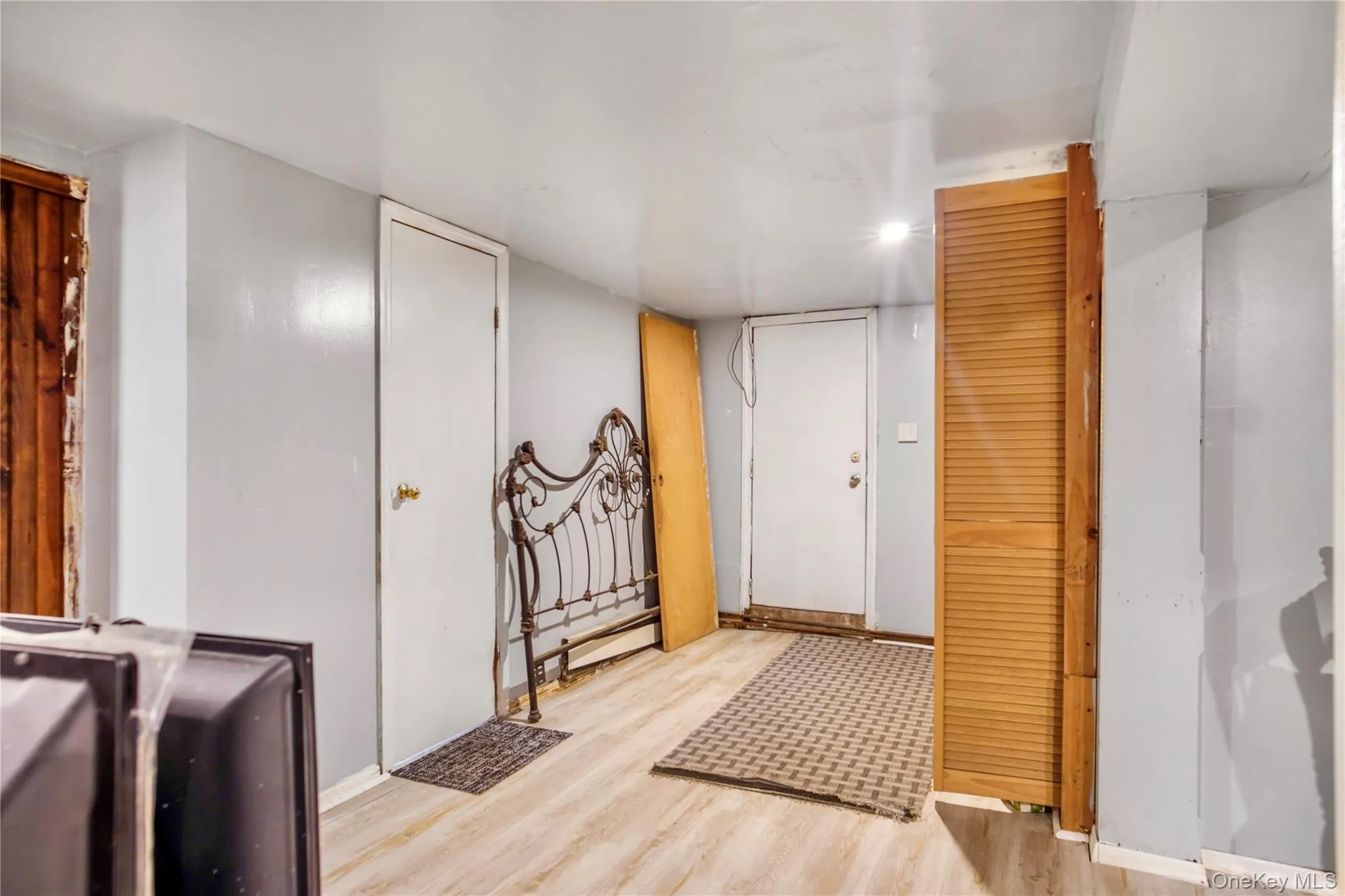 Room featuring light-colored wood-finish flooring, light gray walls, and white ceiling Room featuring light-colored wood-finish flooring, light gray walls, and white ceiling