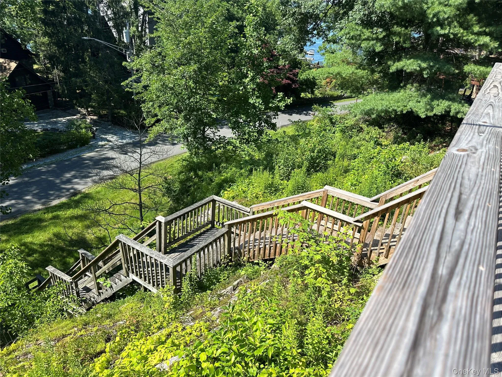 From the front deck are stairs, yes many, leading up to the home from a wide front lawn that can accommodate parking... From the front deck are stairs, yes many, leading up to the home from a wide front lawn that can accommodate parking...