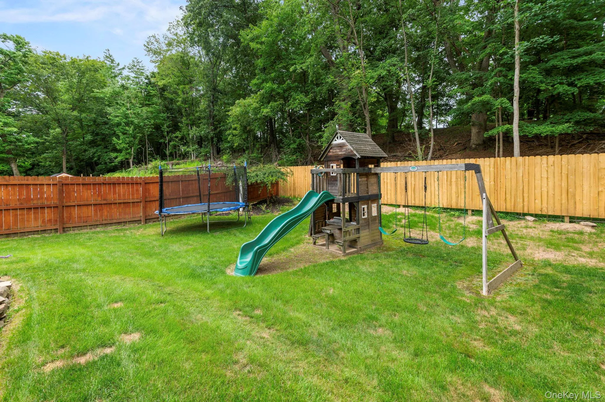 Expansive green lawn with a wood privacy fence Expansive green lawn with a wood privacy fence