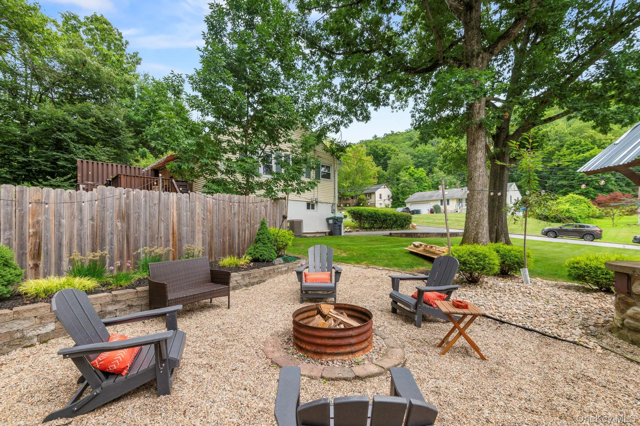 Gravel patio featuring a fire pit, wood privacy fence Gravel patio featuring a fire pit, wood privacy fence