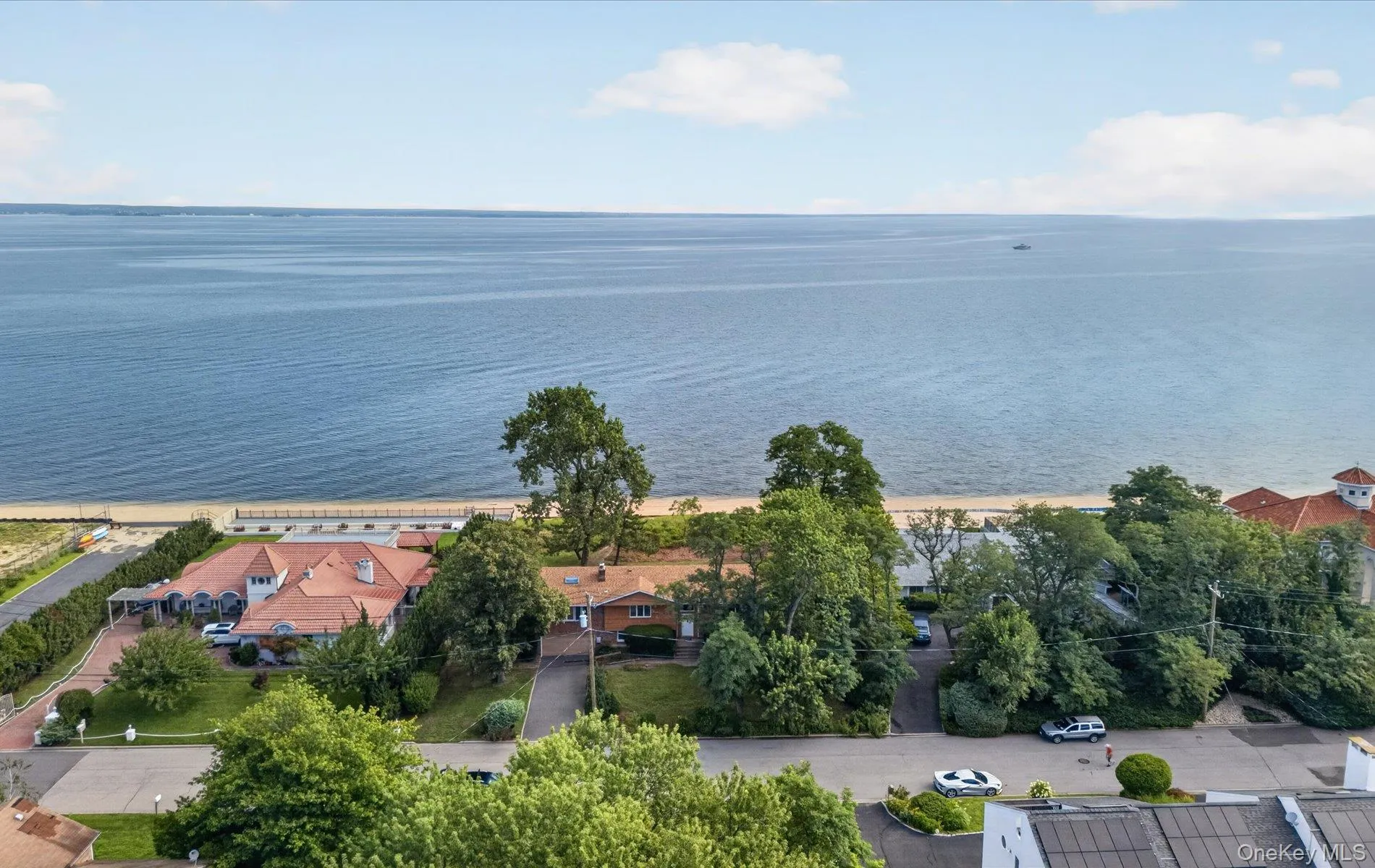Waterfront property with a sandy shoreline, mature trees, and an expansive body of water Waterfront property with a sandy shoreline, mature trees, and an expansive body of water