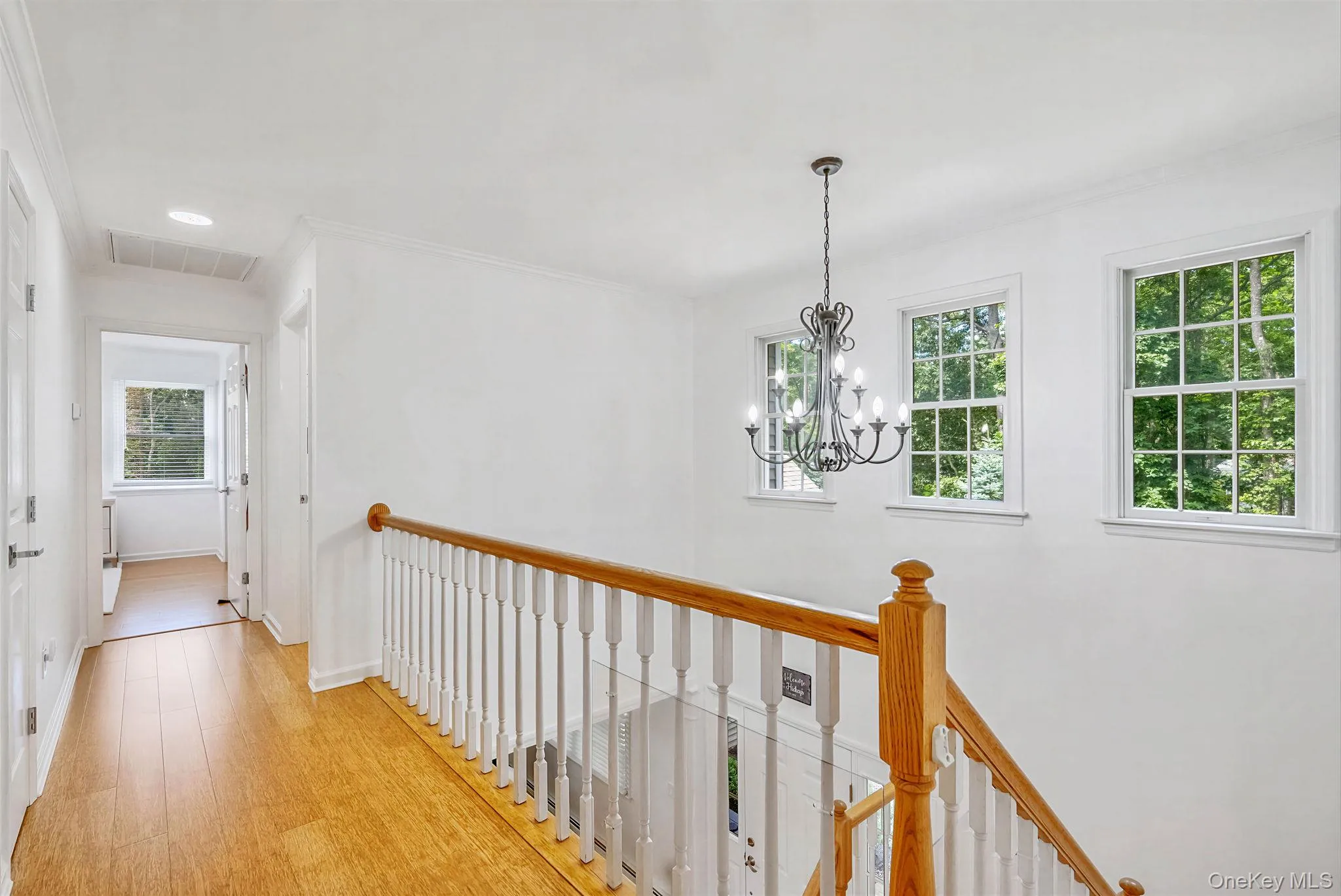 Upstairs hallway and staircase featuring hardwood floors throughout Upstairs hallway and staircase featuring hardwood floors throughout