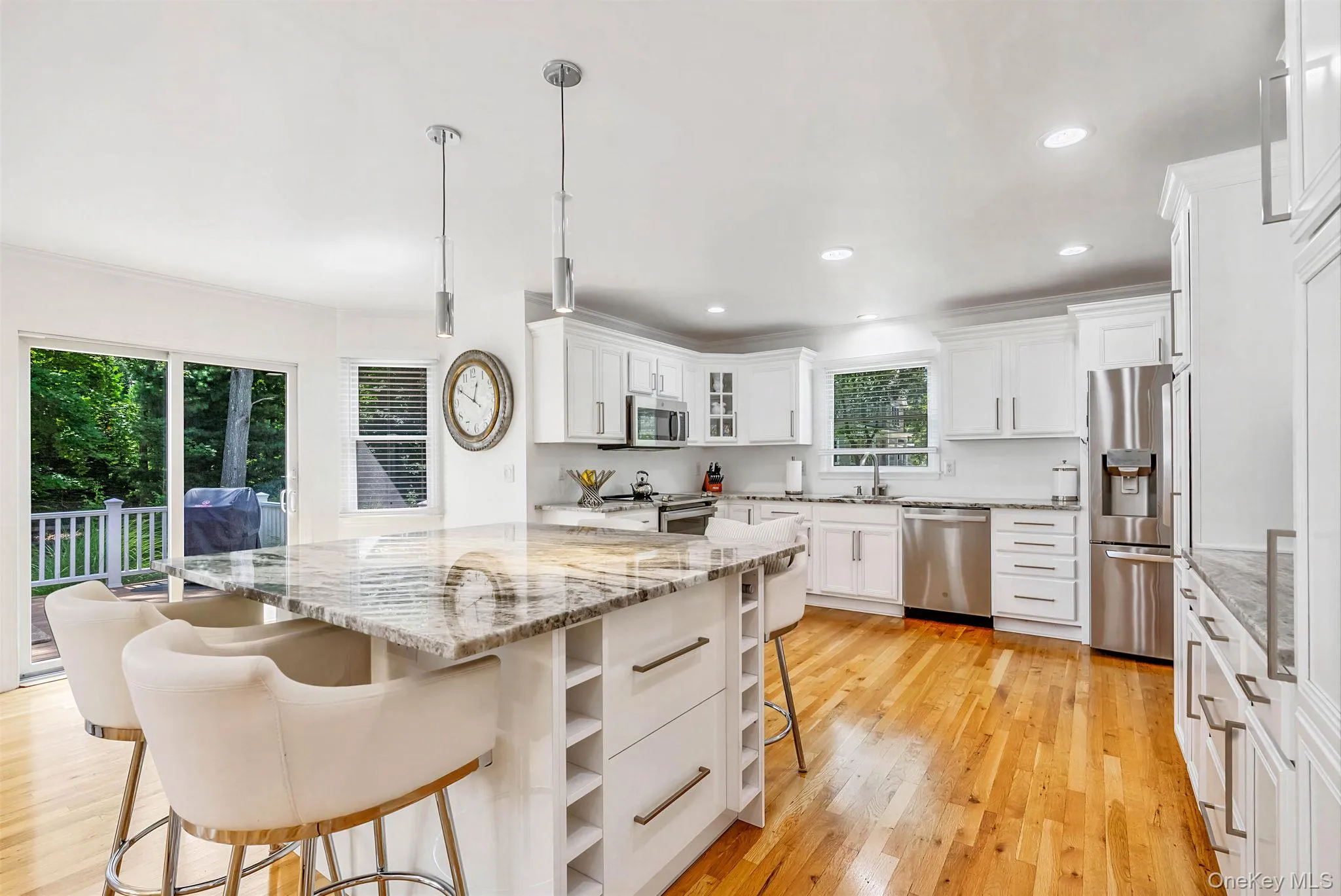 Open kitchen with island, stainless steel appliances and sliding doors to deck Open kitchen with island, stainless steel appliances and sliding doors to deck