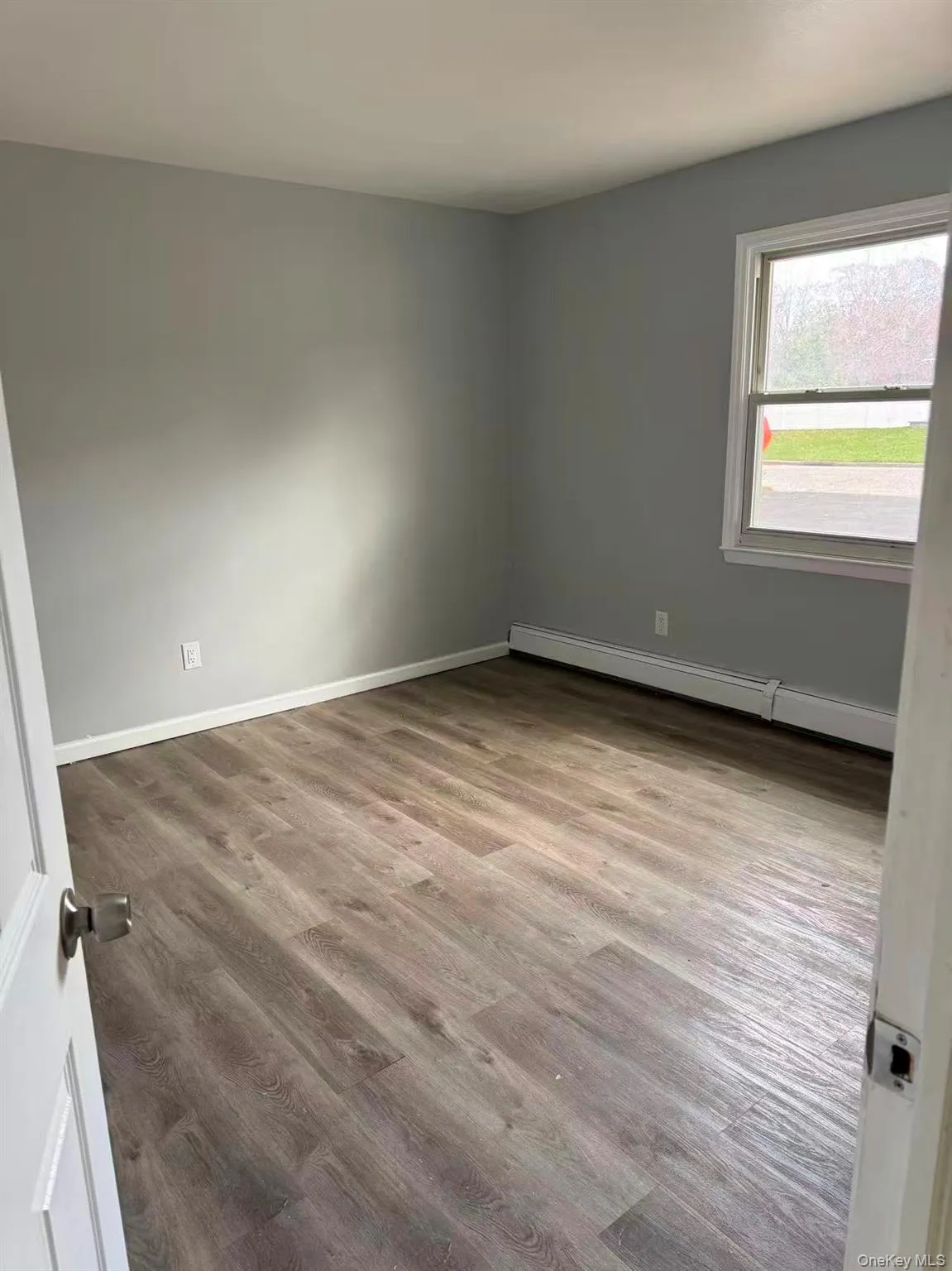 Spare room with a baseboard radiator and light wood-type flooring Spare room with a baseboard radiator and light wood-type flooring