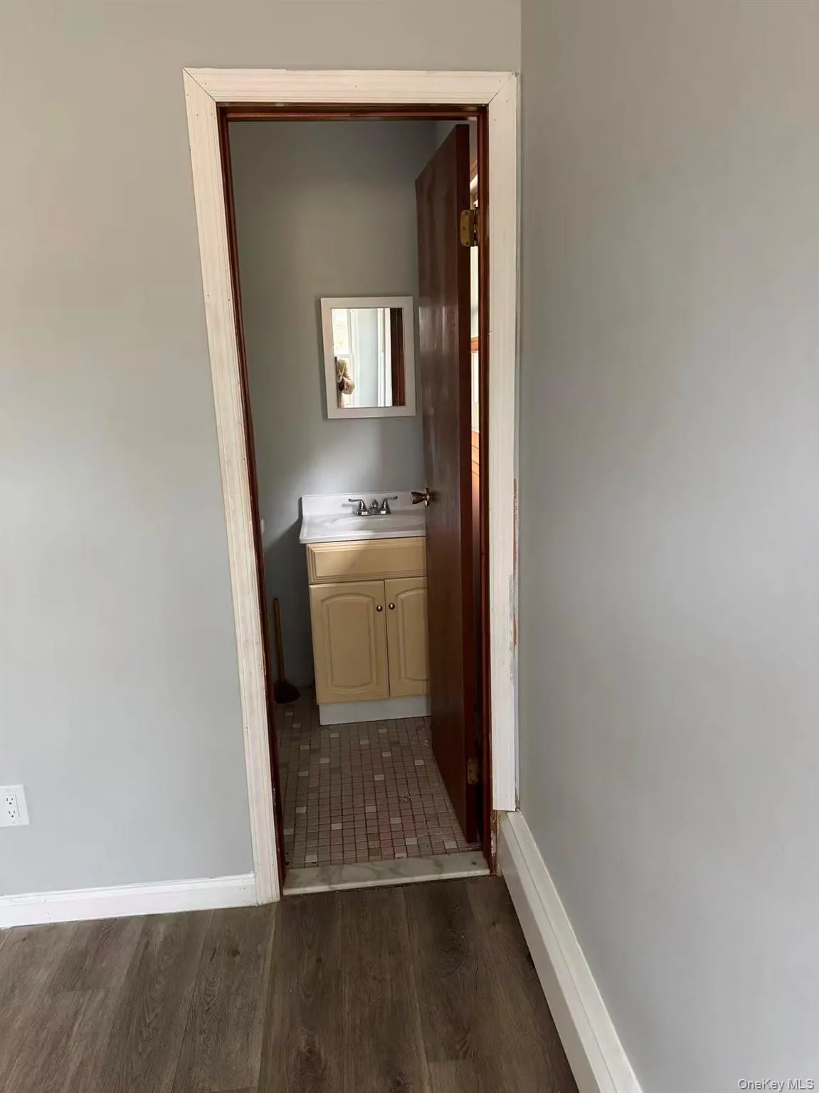 Hallway with dark wood-style floors and baseboards Hallway with dark wood-style floors and baseboards