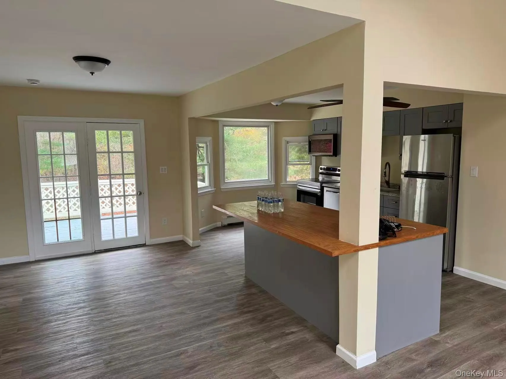 Kitchen with wooden counters, appliances with stainless steel finishes, gray cabinets, and dark wood-style floors Kitchen with wooden counters, appliances with stainless steel finishes, gray cabinets, and dark wood-style floors