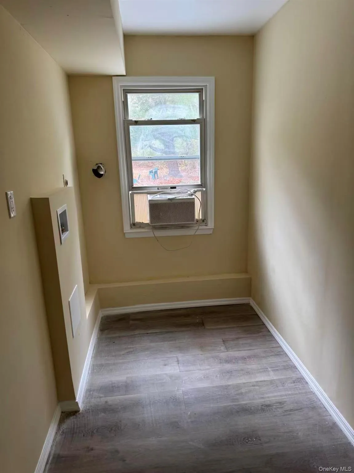 Laundry room with light wood finished floors, hookup for a washing machine, and cooling unit Laundry room with light wood finished floors, hookup for a washing machine, and cooling unit