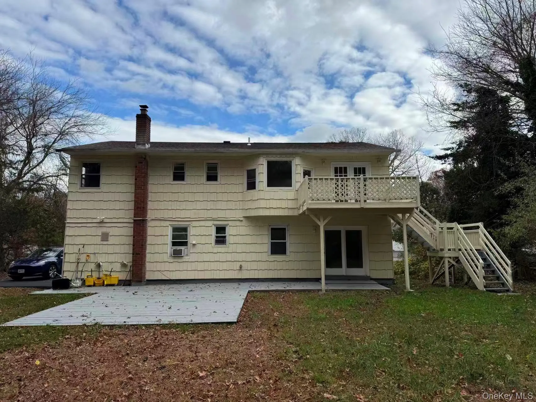 Back of house featuring stairway, a patio area, a deck, a chimney, and a lawn Back of house featuring stairway, a patio area, a deck, a chimney, and a lawn
