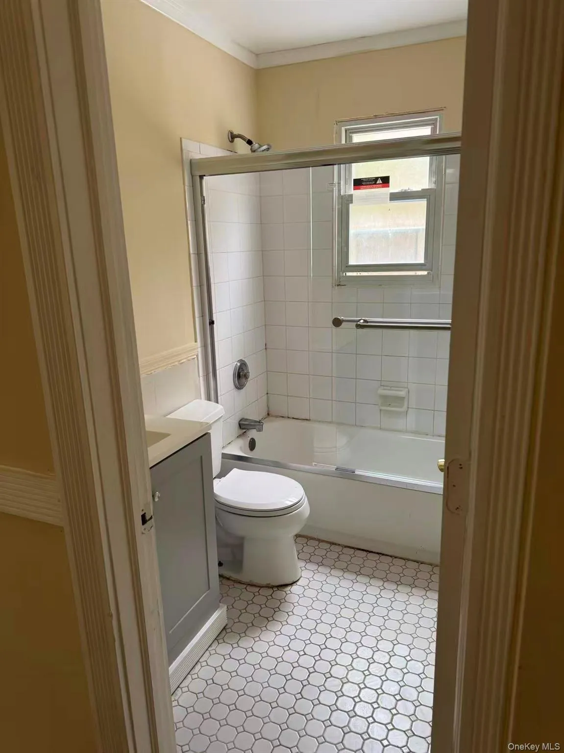 Bathroom featuring combined bath / shower with glass door, vanity, crown molding, and light tile patterned flooring Bathroom featuring combined bath / shower with glass door, vanity, crown molding, and light tile patterned flooring