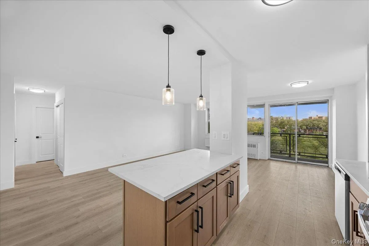 Open concept living space with light-tone vinyl flooring, white walls Open concept living space with light-tone vinyl flooring, white walls