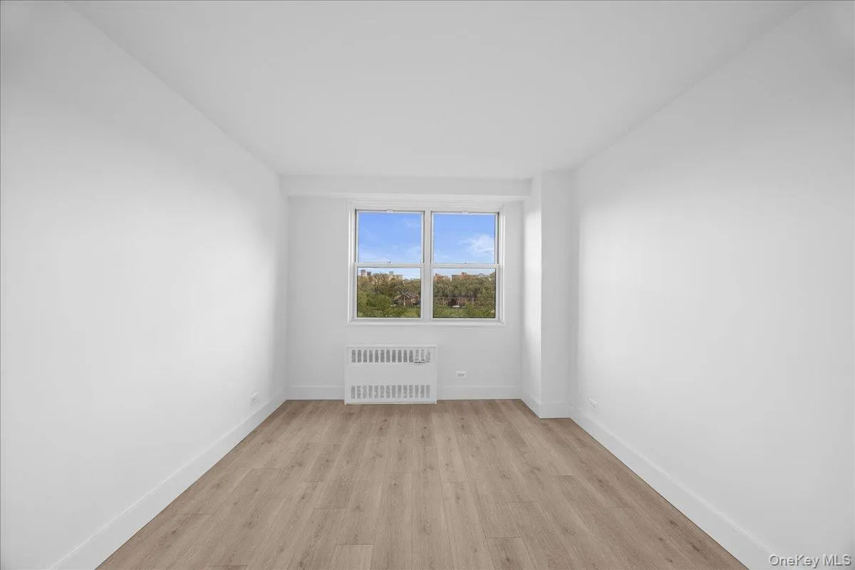 Bright interior space featuring a light vinyl, white walls, and a white interior door with dark hardware Bright interior space featuring a light vinyl, white walls, and a white interior door with dark hardware