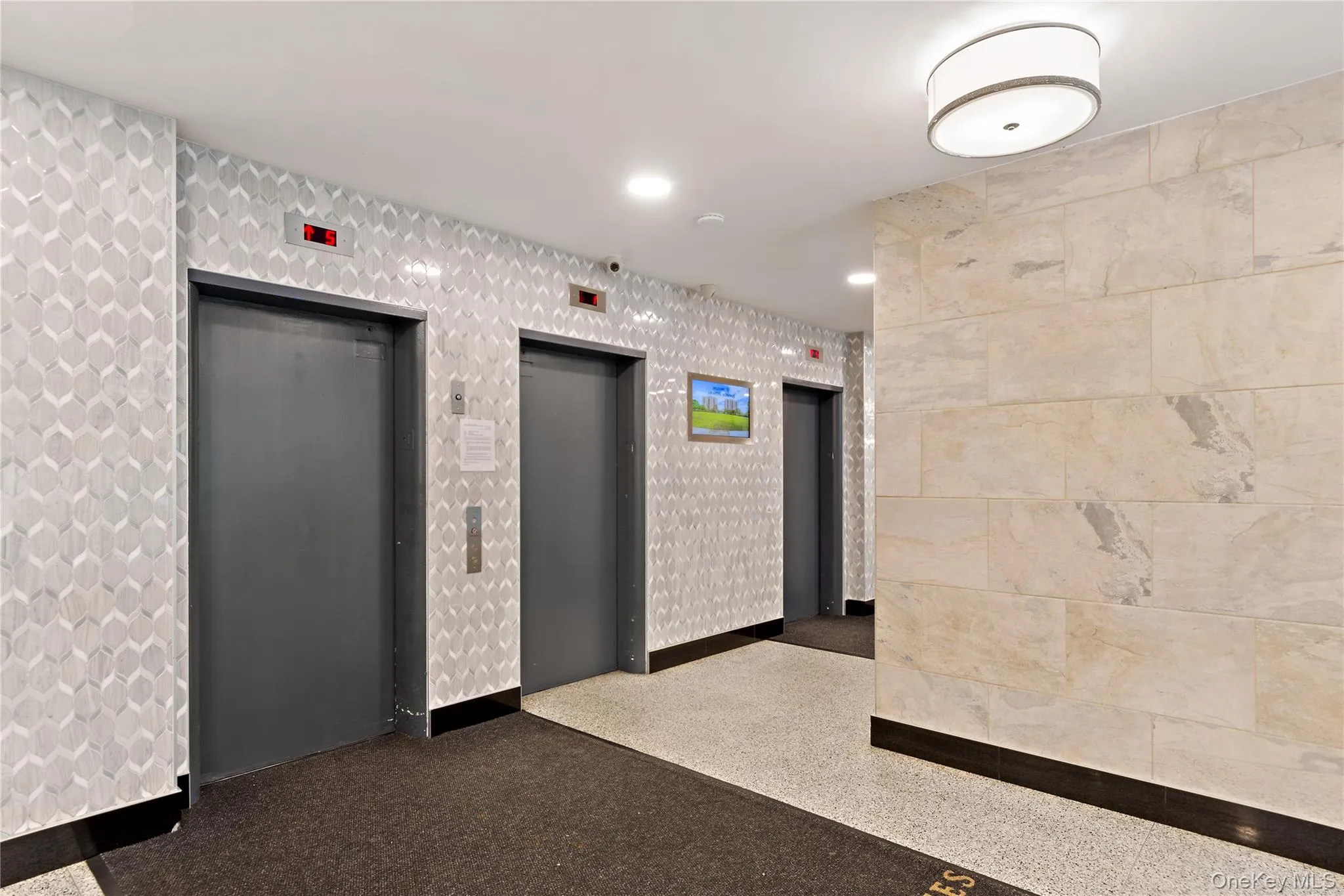Textured accent wall, terrazzo flooring, flush-mount ceiling lighting, natural stone wall cladding, and stainless steel railings Textured accent wall, terrazzo flooring, flush-mount ceiling lighting, natural stone wall cladding, and stainless steel railings