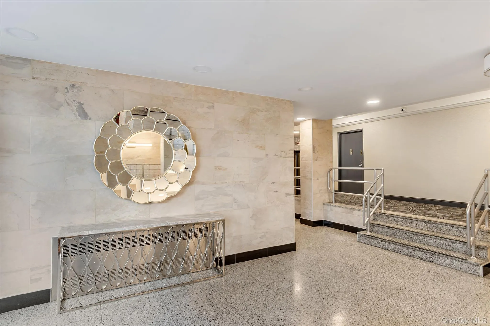 Textured accent wall, terrazzo flooring, flush-mount ceiling lighting, natural stone wall cladding, and stainless steel railings Textured accent wall, terrazzo flooring, flush-mount ceiling lighting, natural stone wall cladding, and stainless steel railings