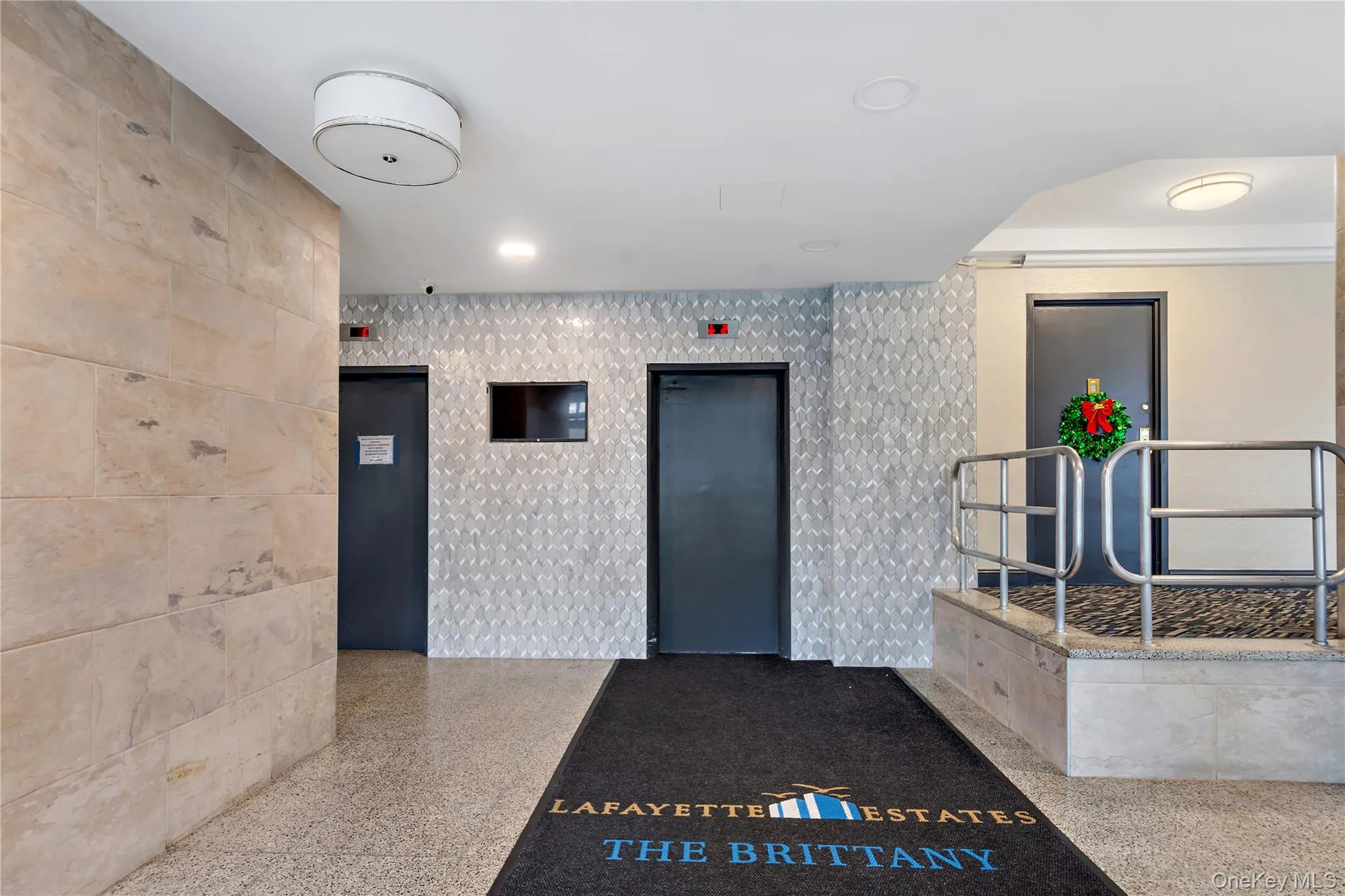 Textured accent wall, terrazzo flooring, flush-mount ceiling lighting, natural stone wall cladding, and stainless steel railings Textured accent wall, terrazzo flooring, flush-mount ceiling lighting, natural stone wall cladding, and stainless steel railings