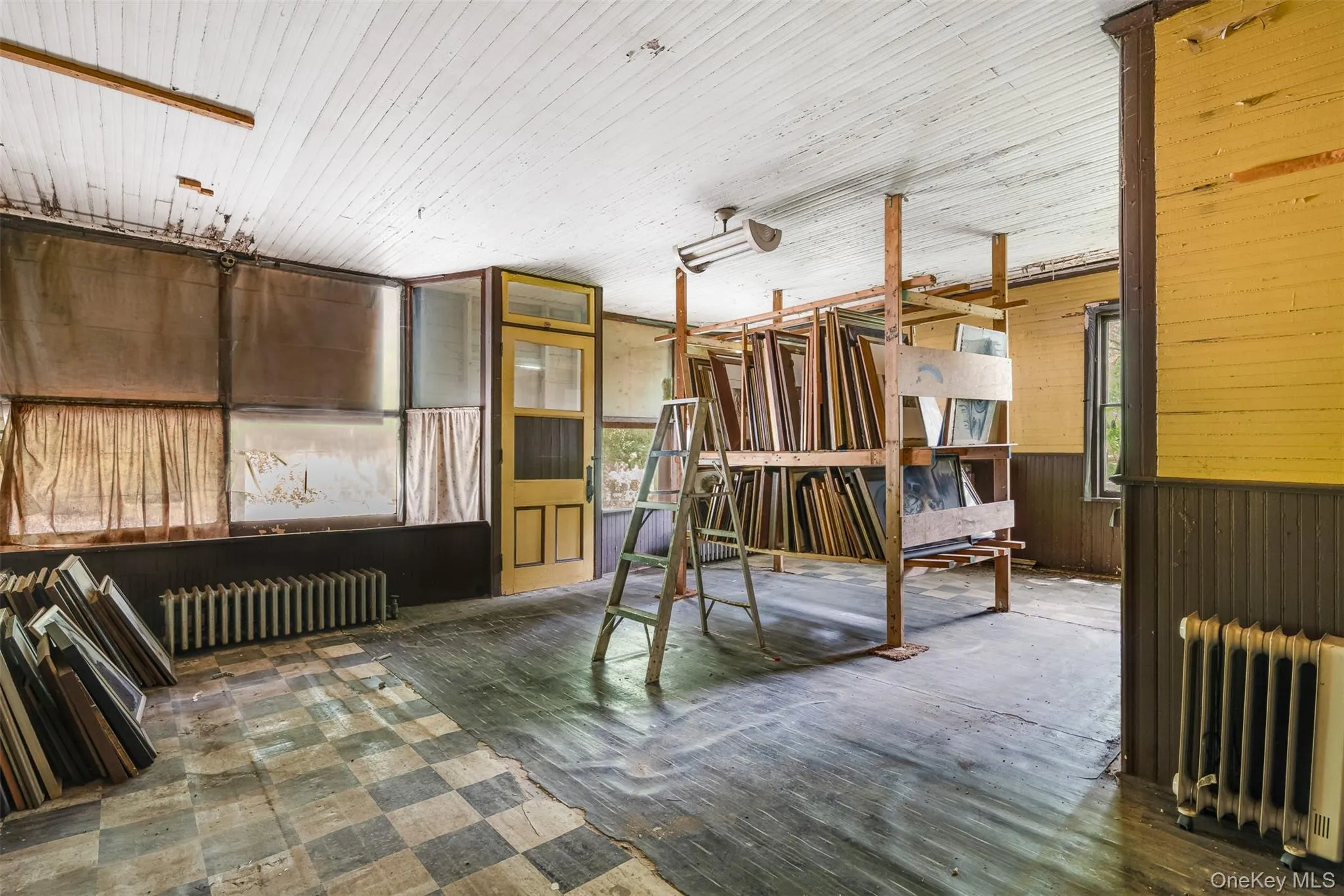 Miscellaneous room featuring radiator and wooden walls Miscellaneous room featuring radiator and wooden walls