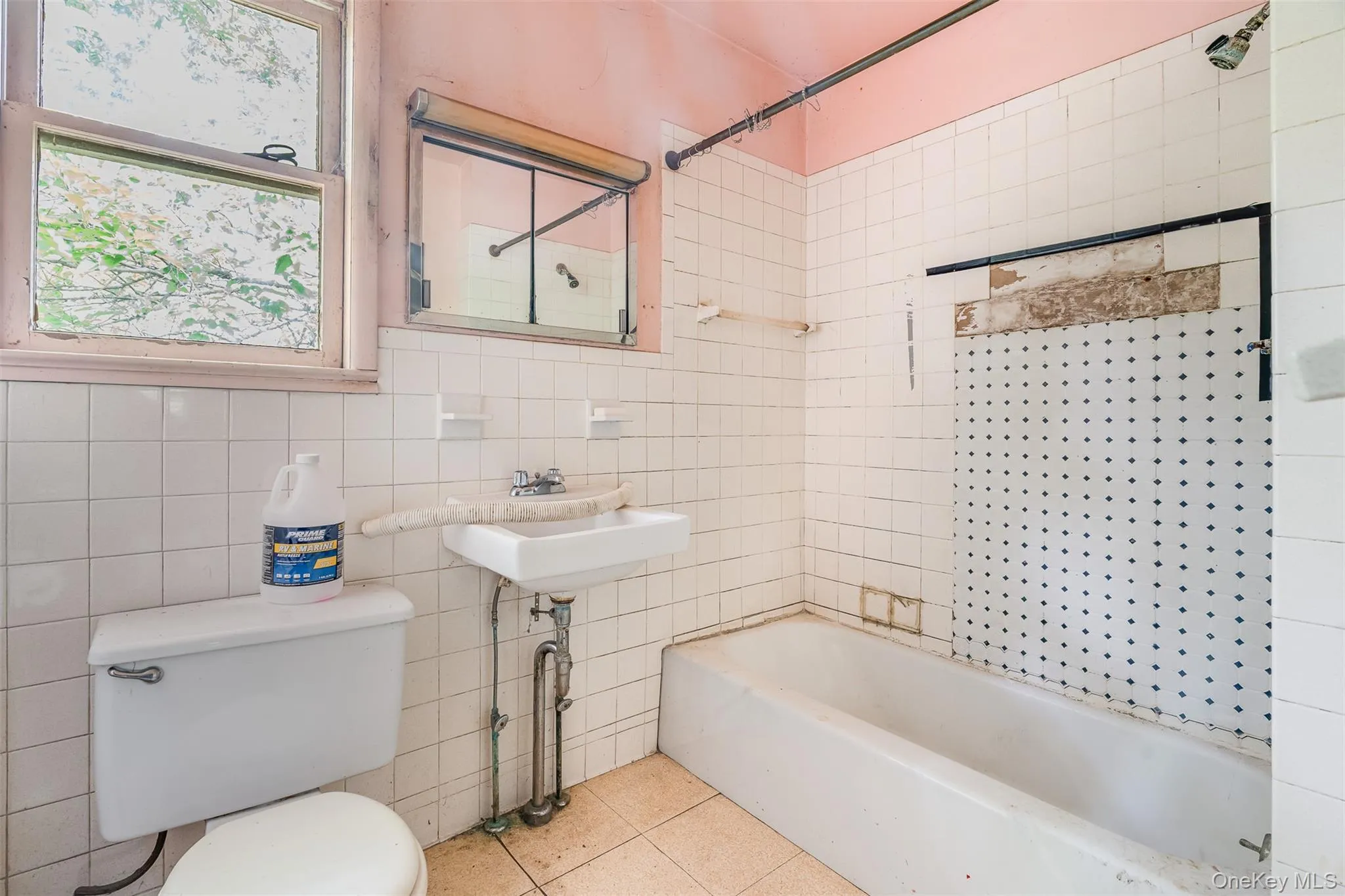 Bathroom with tile walls, shower / washtub combination, and tile patterned flooring Bathroom with tile walls, shower / washtub combination, and tile patterned flooring