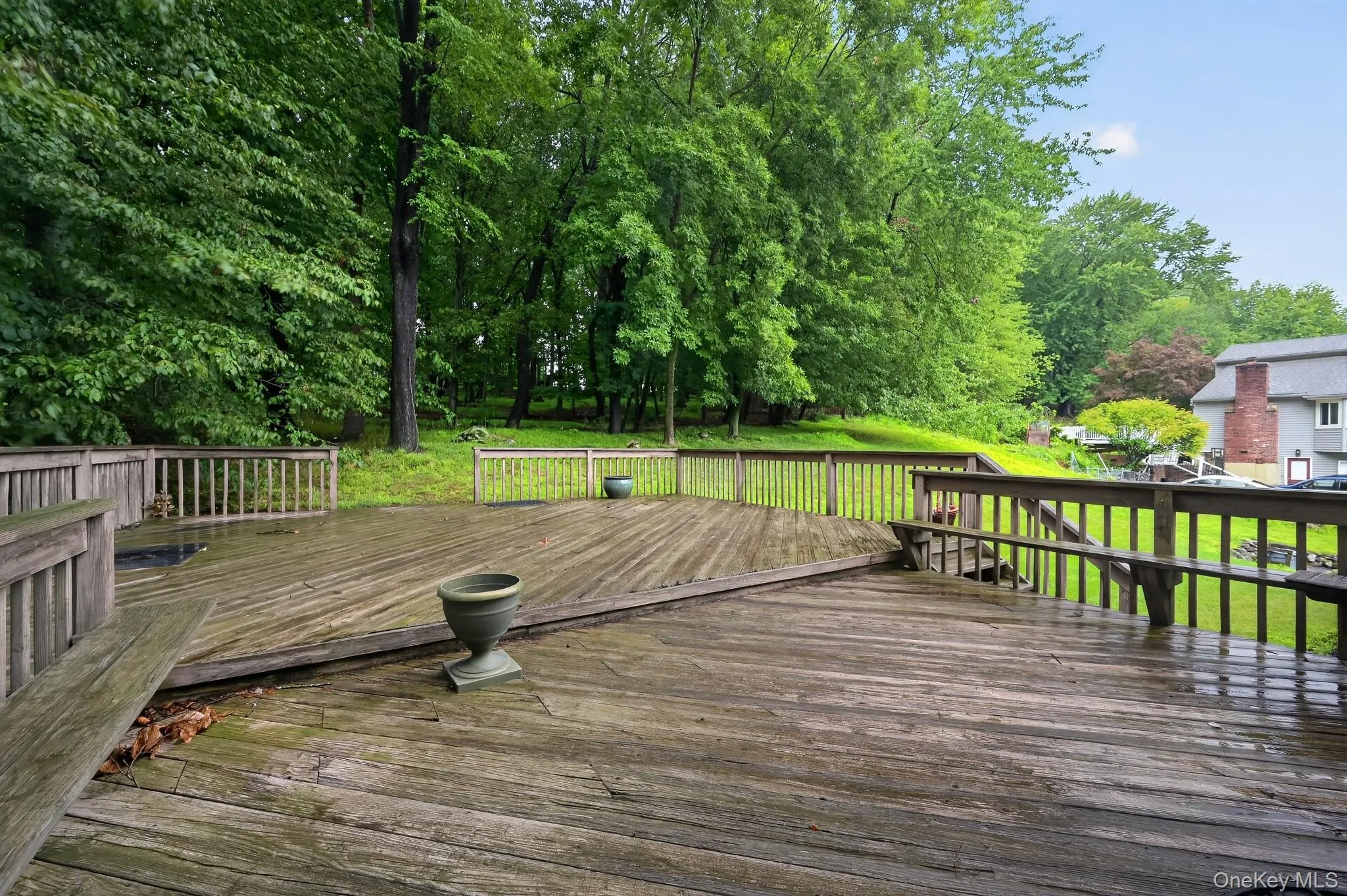 A spacious, party-sized wood deck perfect for outdoor entertaining, stepping out into a quiet, private backyard framed by lush, mature trees in Valley Cottage, New York. A spacious, party-sized wood deck perfect for outdoor entertaining, stepping out into a quiet, private backyard framed by lush, mature trees in Valley Cottage, New York.