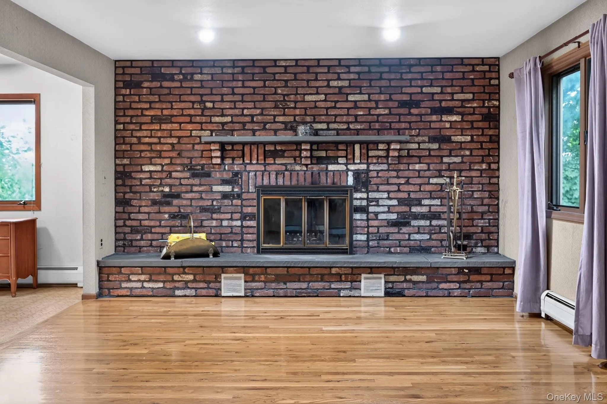 Brick-faced fireplace with a stone mantel and hearth Brick-faced fireplace with a stone mantel and hearth