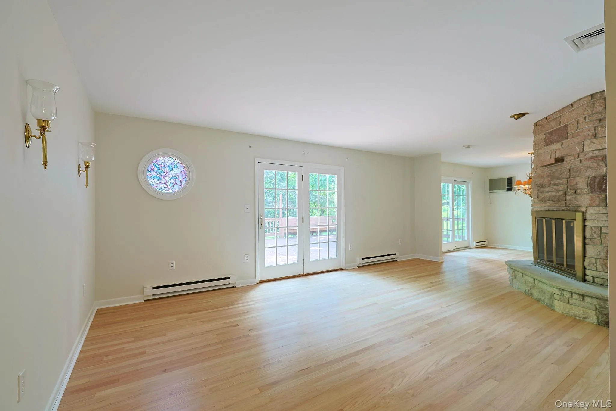 Open living room with deck access and fireplace. Open living room with deck access and fireplace.