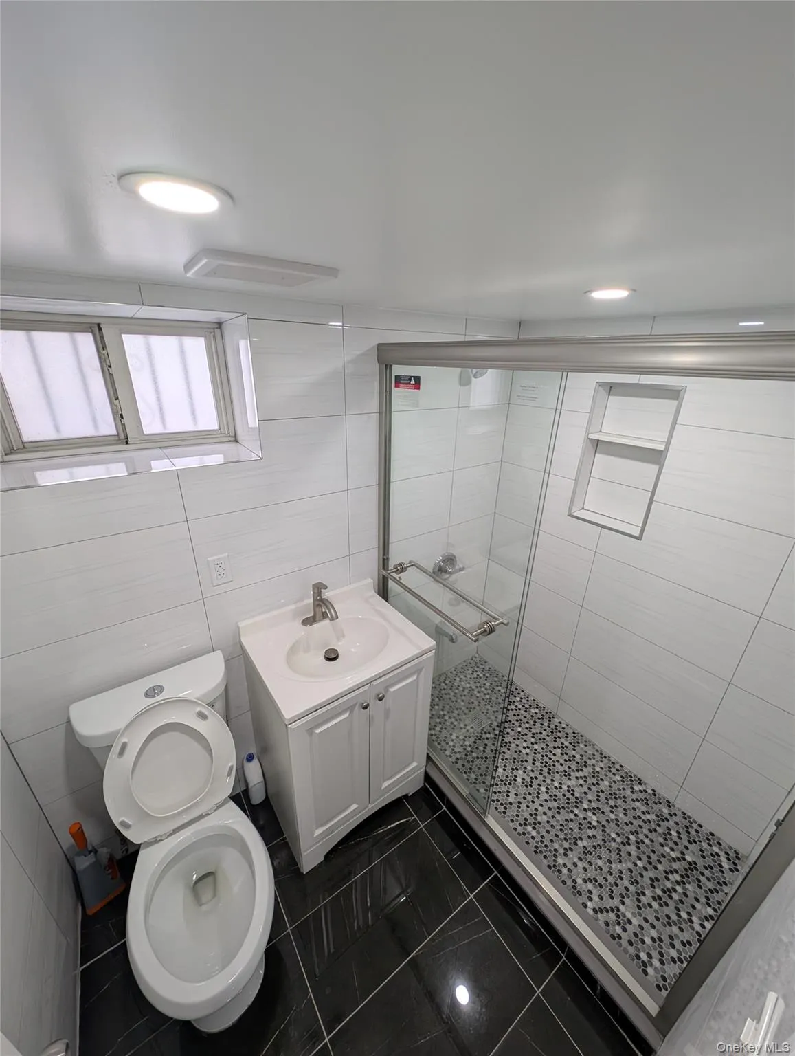 Bathroom featuring a shower stall, vanity, visible vents, toilet, and marble finish floor Bathroom featuring a shower stall, vanity, visible vents, toilet, and marble finish floor