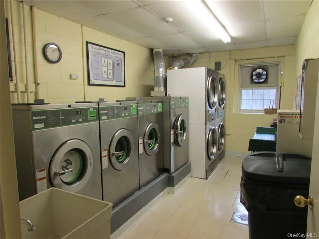 Laundry area featuring sink and stacked washer and clothes dryer Laundry area featuring sink and stacked washer and clothes dryer