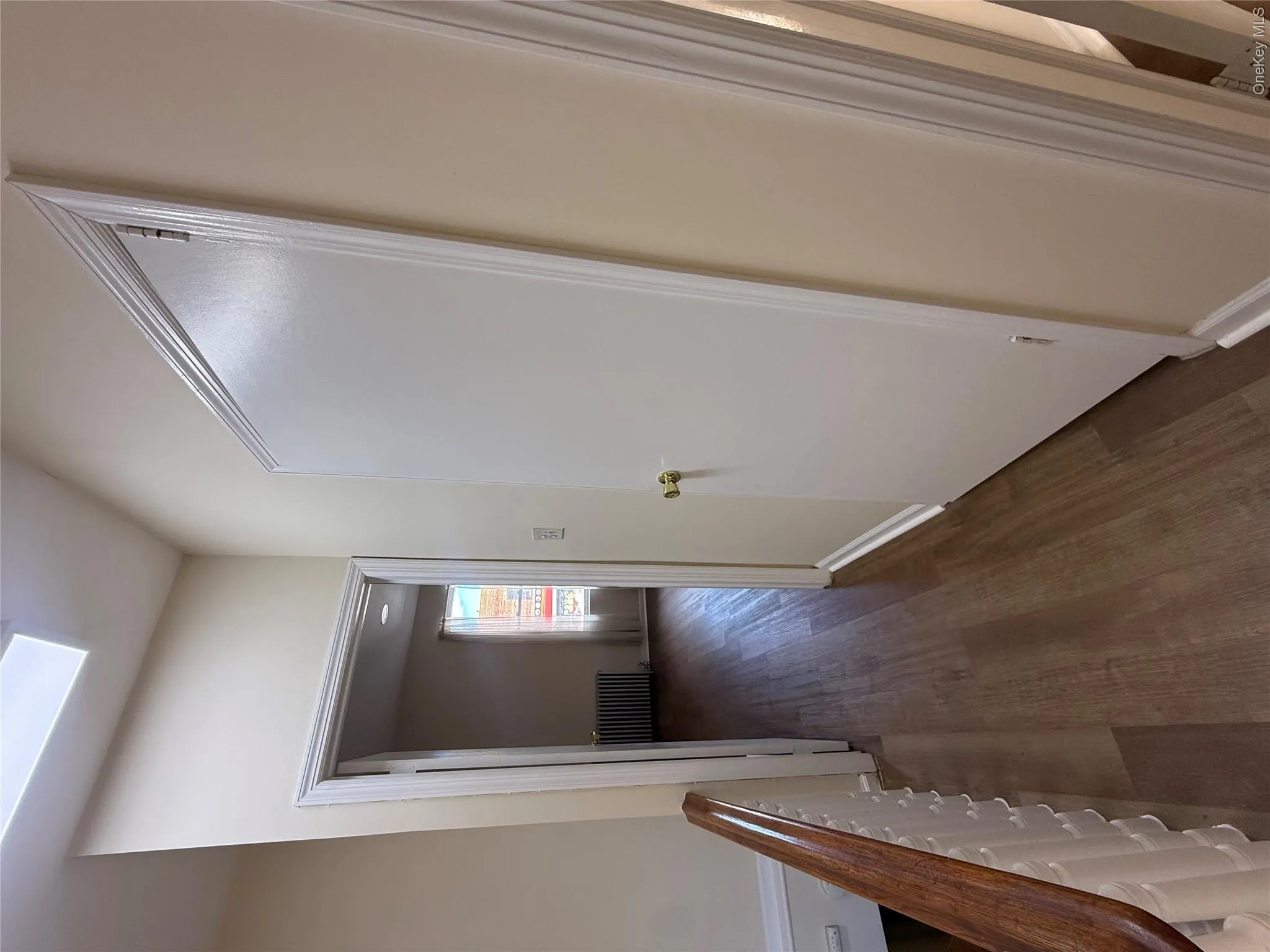 Corridor featuring dark wood-style floors, radiator, and a skylight Corridor featuring dark wood-style floors, radiator, and a skylight