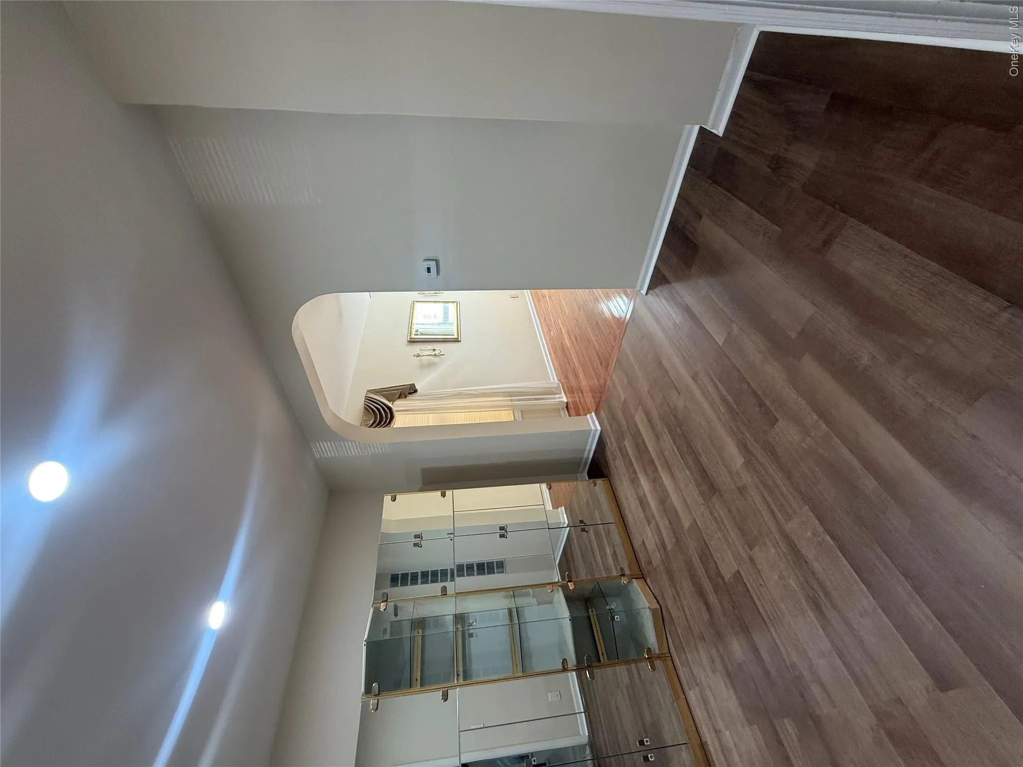 Unfurnished living room featuring dark wood-style flooring, arched walkways, and recessed lighting Unfurnished living room featuring dark wood-style flooring, arched walkways, and recessed lighting