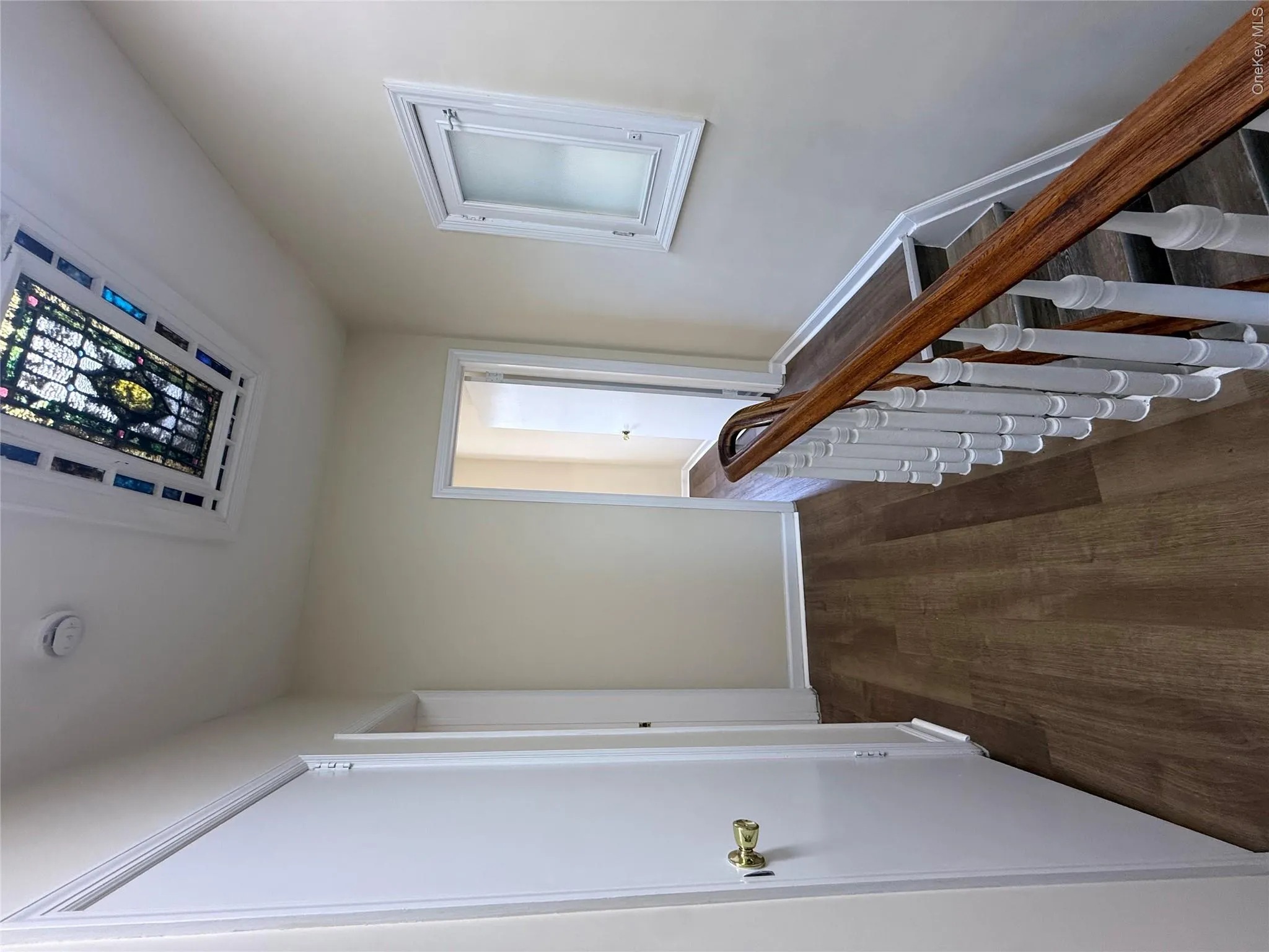 Hall featuring dark wood-style floors and an upstairs landing Hall featuring dark wood-style floors and an upstairs landing