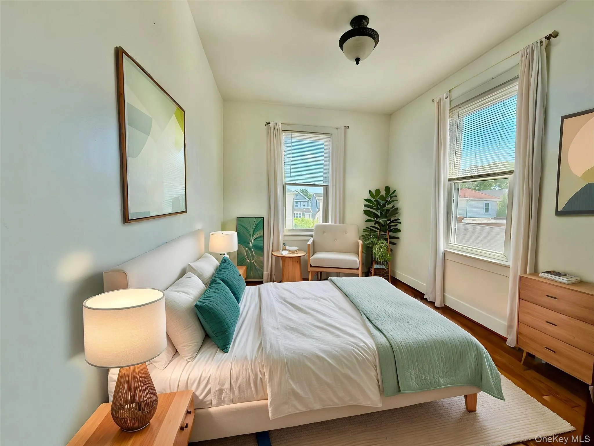 Hardwood flooring, two large windows with blinds, ceiling-mounted light fixture, light-colored walls, and a built-in closet Hardwood flooring, two large windows with blinds, ceiling-mounted light fixture, light-colored walls, and a built-in closet