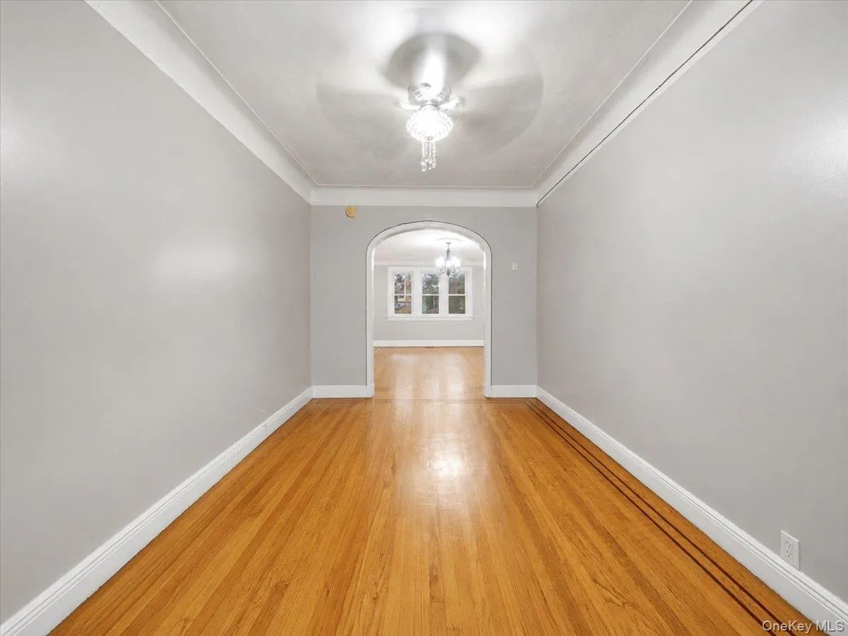 Hardwood flooring, arched doorway, recessed ceiling, flush mount chandelier, light gray wall paint Hardwood flooring, arched doorway, recessed ceiling, flush mount chandelier, light gray wall paint